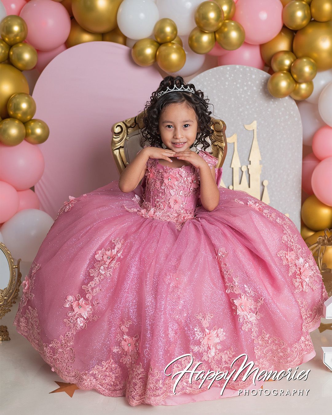 Pink and gold balloon backdrop creates an elegant setting for a special celebration with a formal gown.