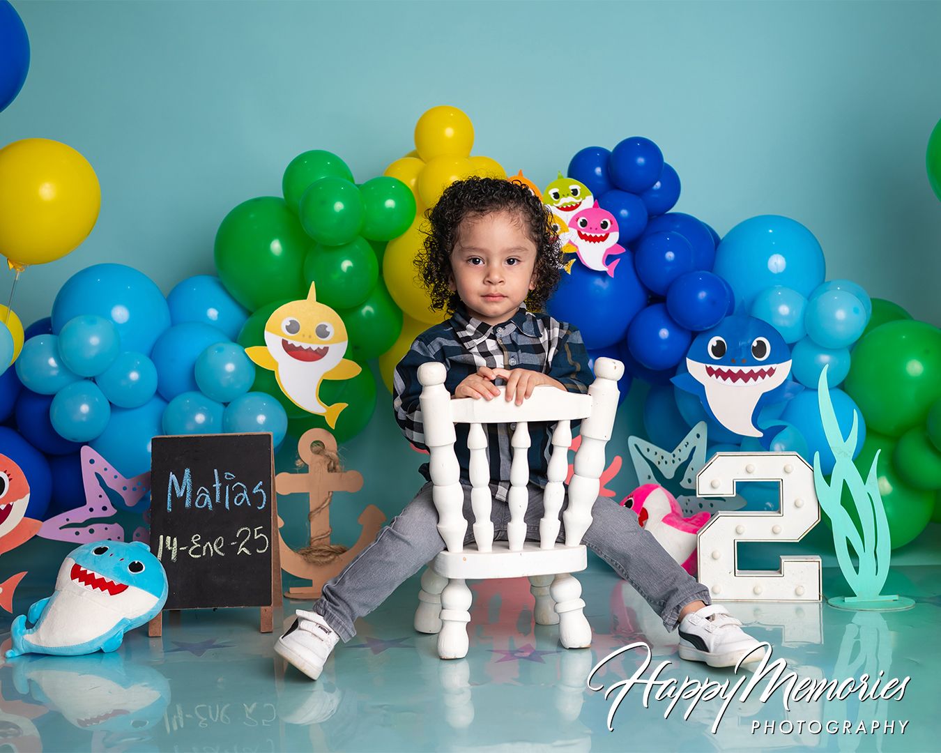 Under the sea themed birthday setup with blue and green balloons featuring shark and ocean decorations.
