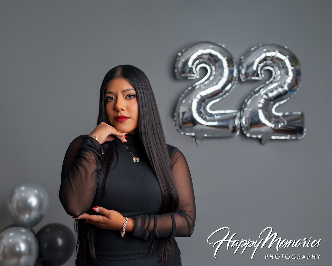 Studio portraits with silver number 22 balloons and black ensemble.