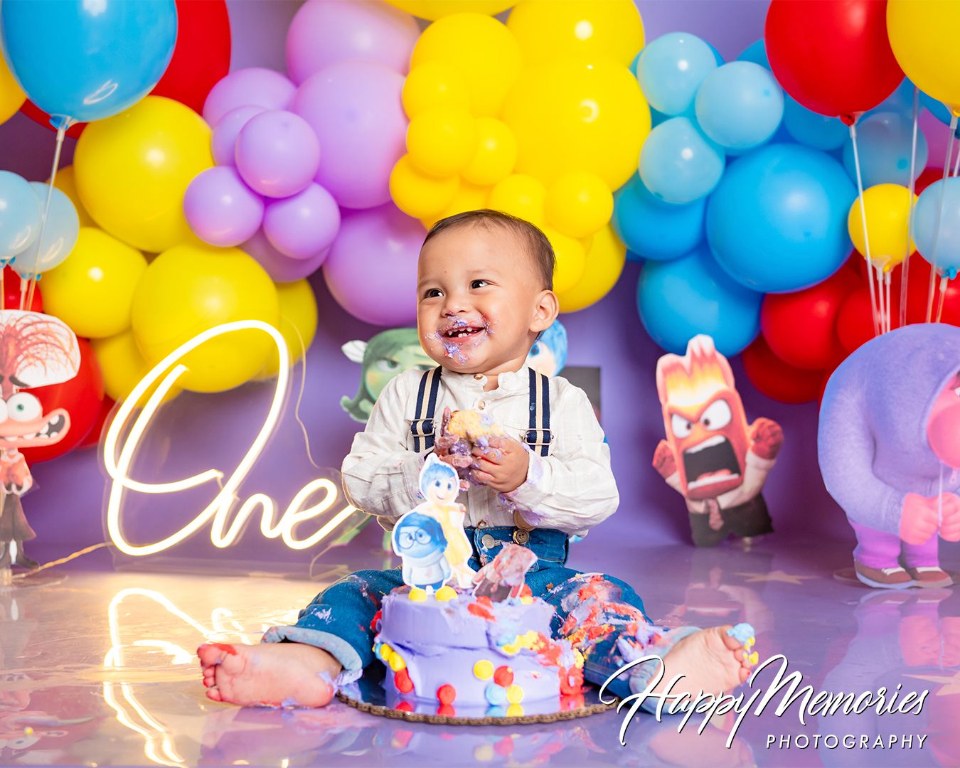 Vibrant rainbow balloon arch with multicolored balloons creating a cheerful birthday backdrop.