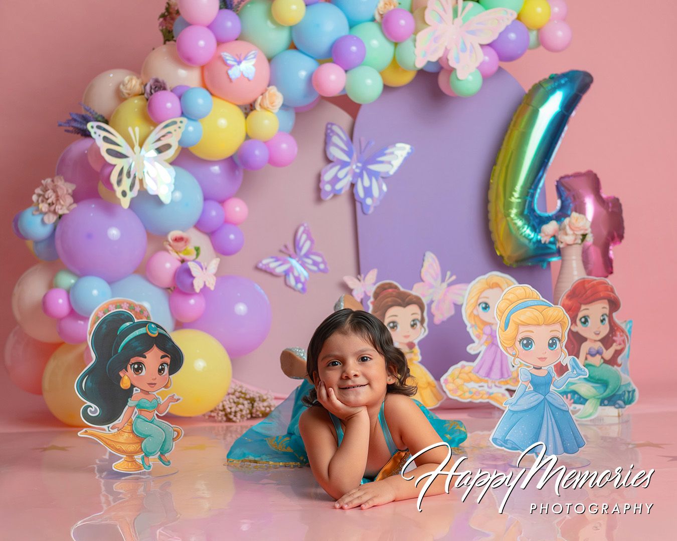A girl poses at a Disney princess 4th birthday party with colorful balloons, butterflies, and princess cutouts.
