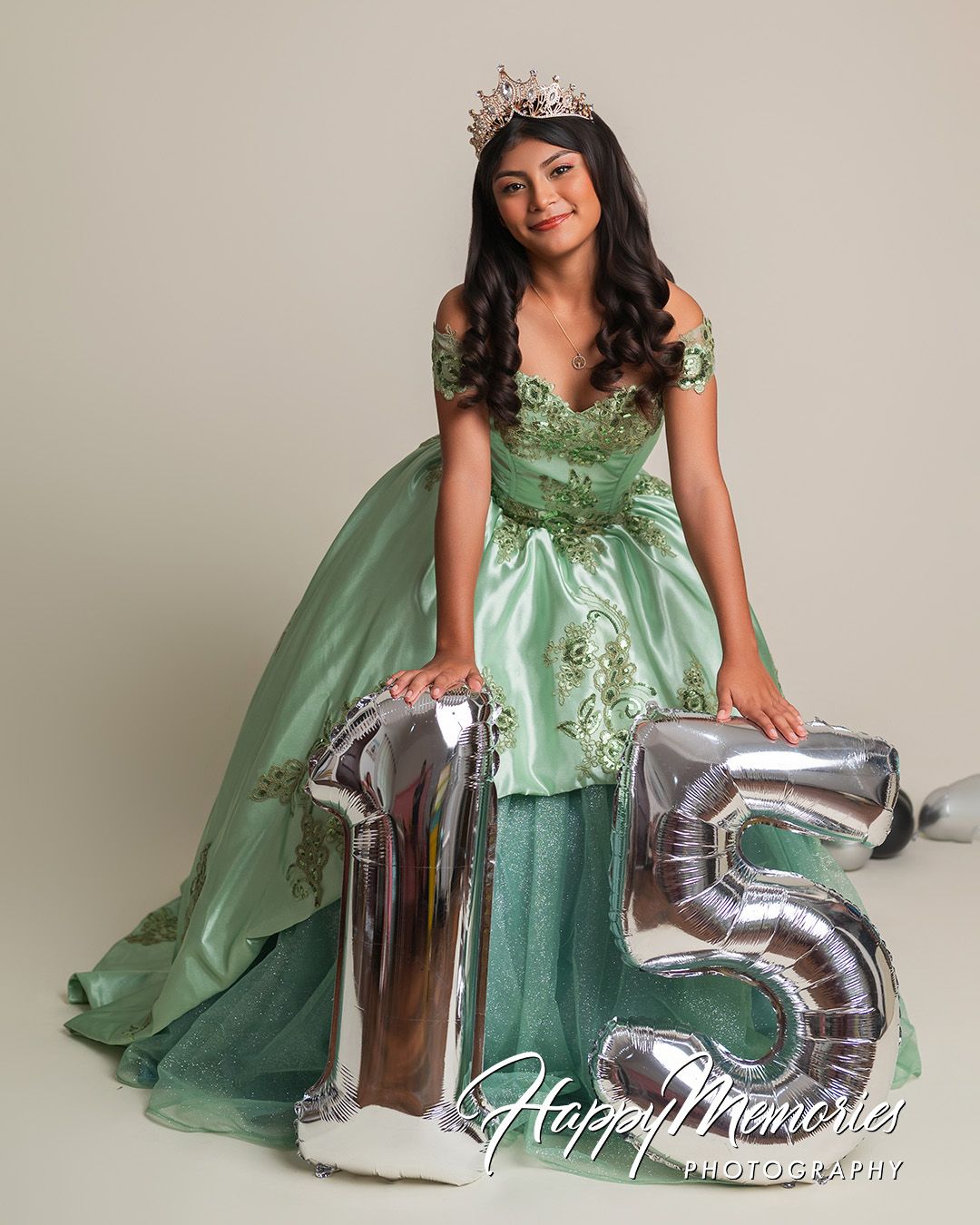Celebratory portraits in mint green princess gown with silver number balloons.