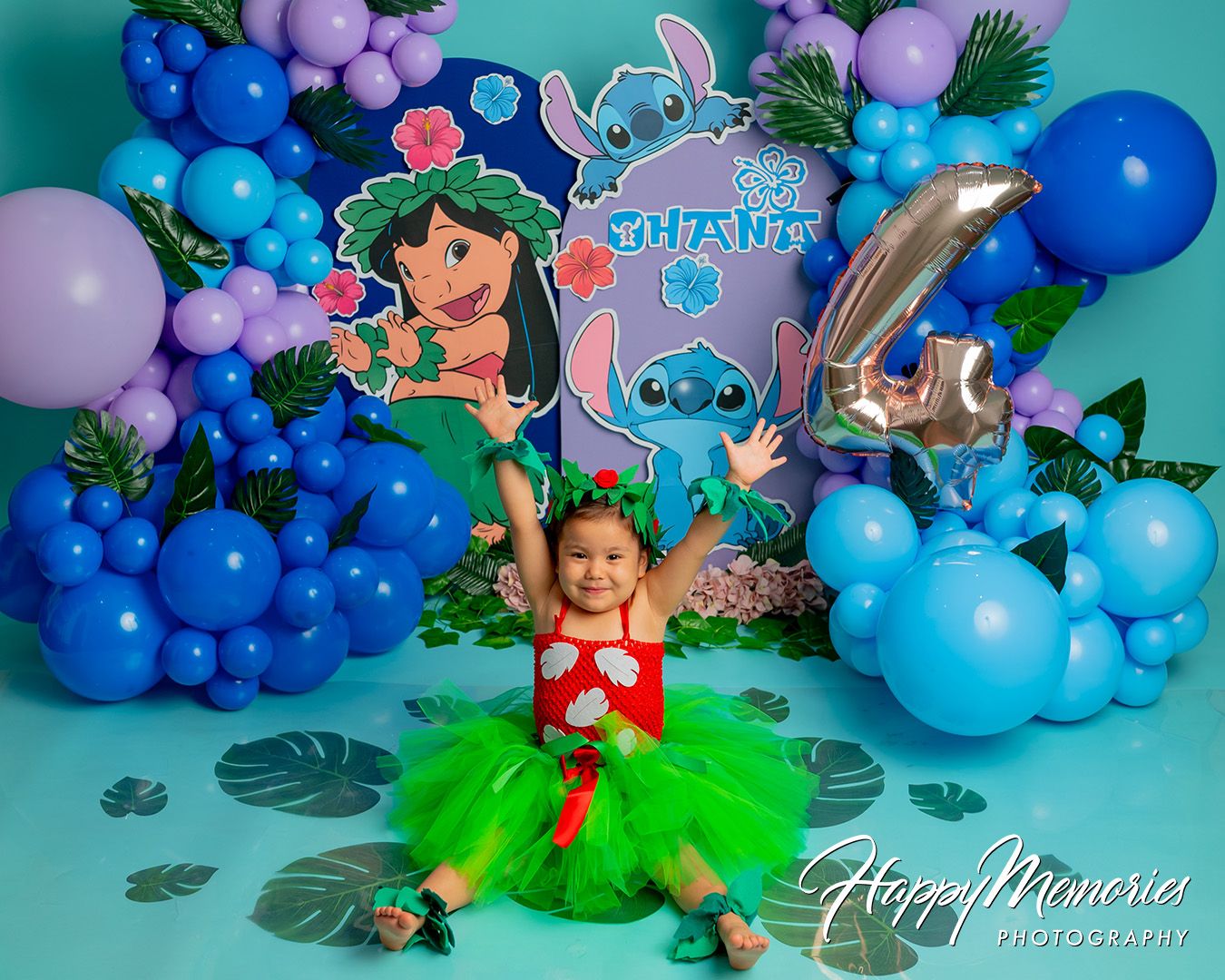 Lilo and Stitch themed birthday party setup with blue and purple balloon garlands and tropical decorations.