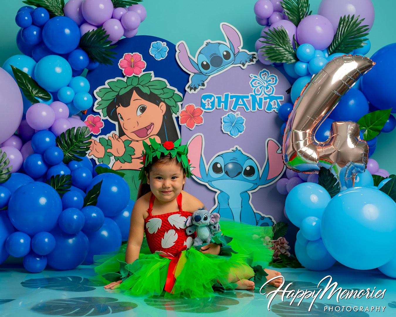 A whimsical underwater-themed photo setup with blue and purple balloons, decorative elements, and tropical sea creature designs.