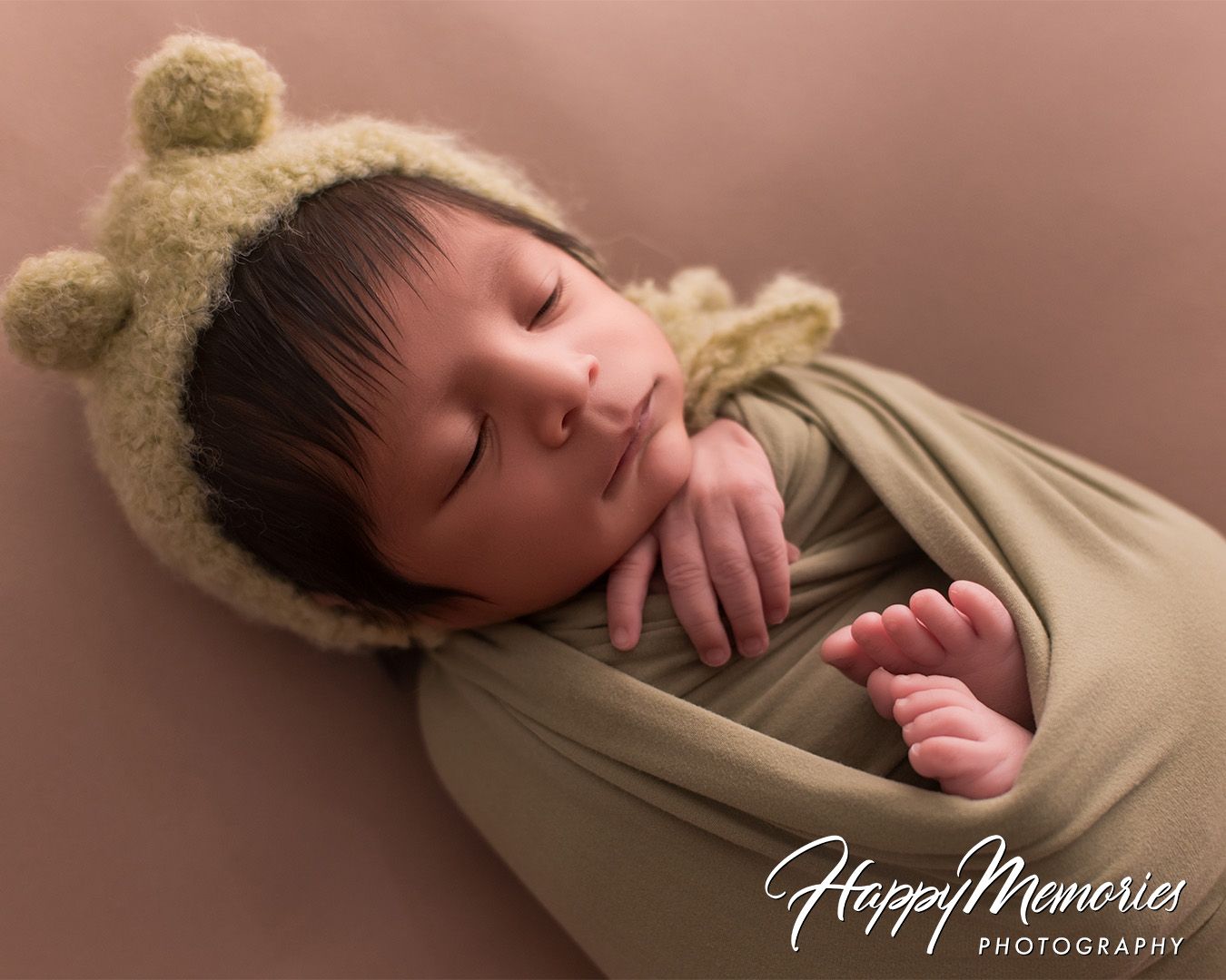 Artistic newborn photo series with baby wearing beige wrap and bear ear accessories.