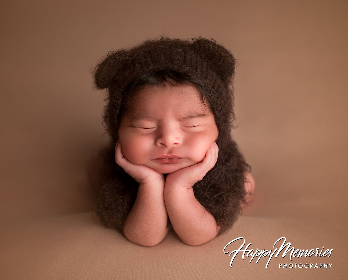 Professional newborn portrait in warm brown tones showing peaceful sleeping pose.