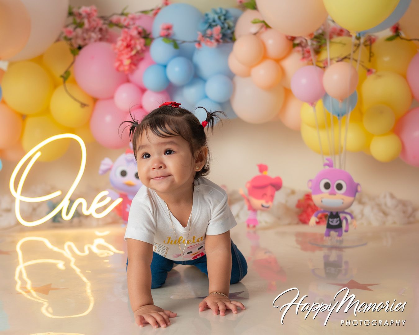 Colorful balloon garland with pink, yellow, blue and orange balloons decorating a festive party setting.