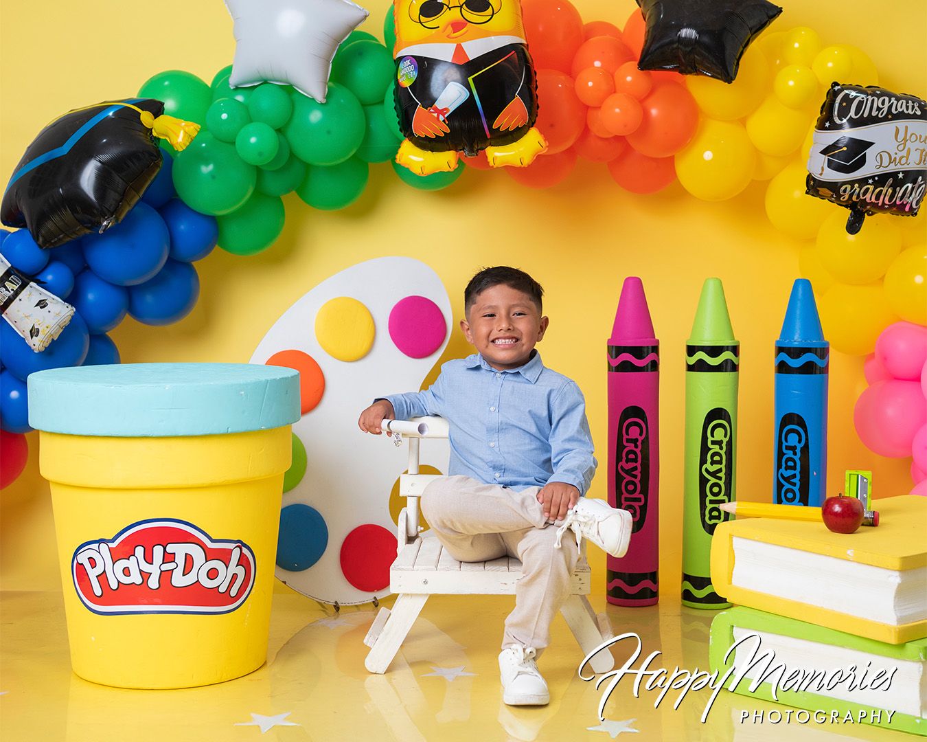 Creative education themed photo setup with Play-Doh containers and balloon arch.