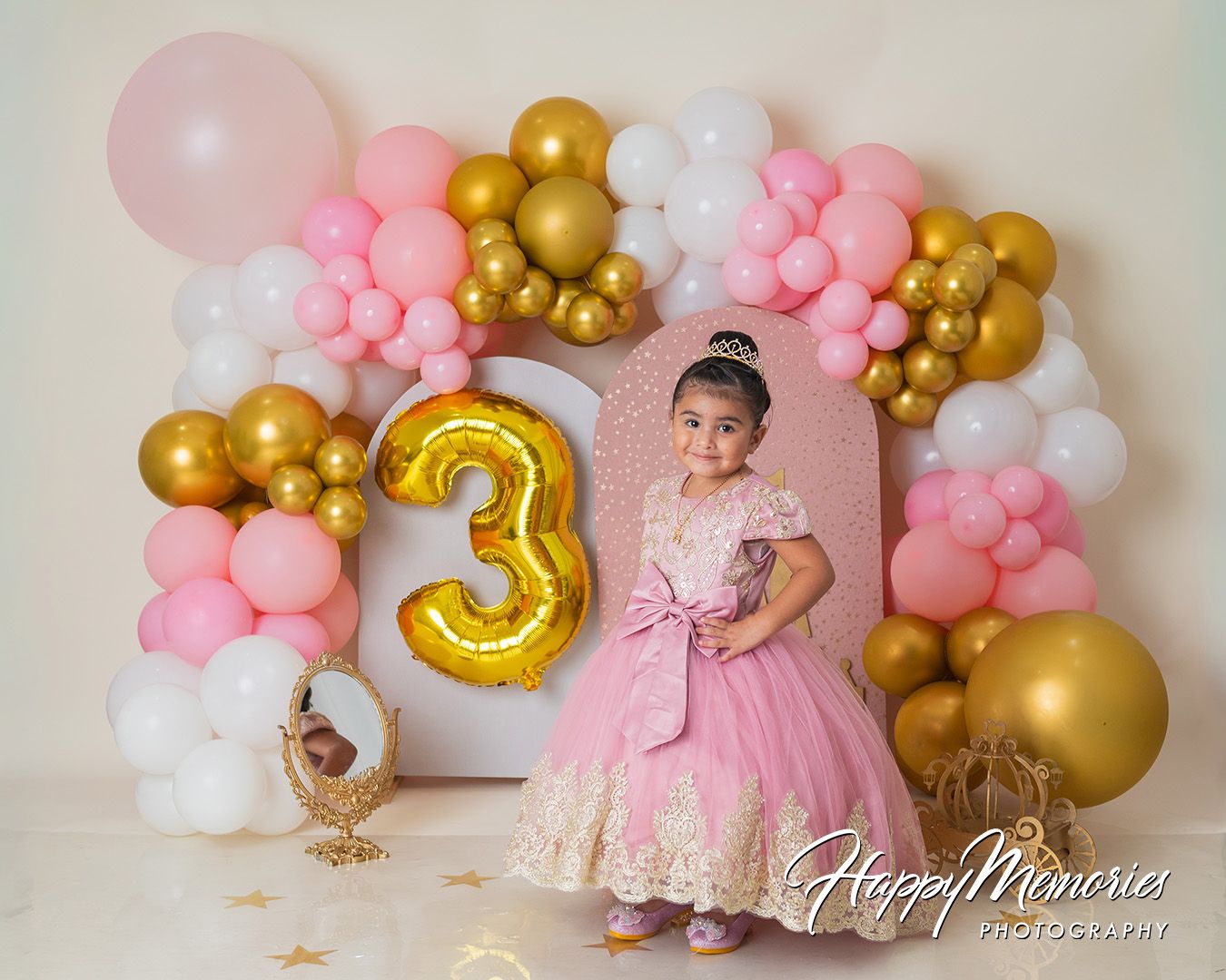 Pink and gold balloon garland with number 3 balloon and teddy bear decorations for a birthday celebration.