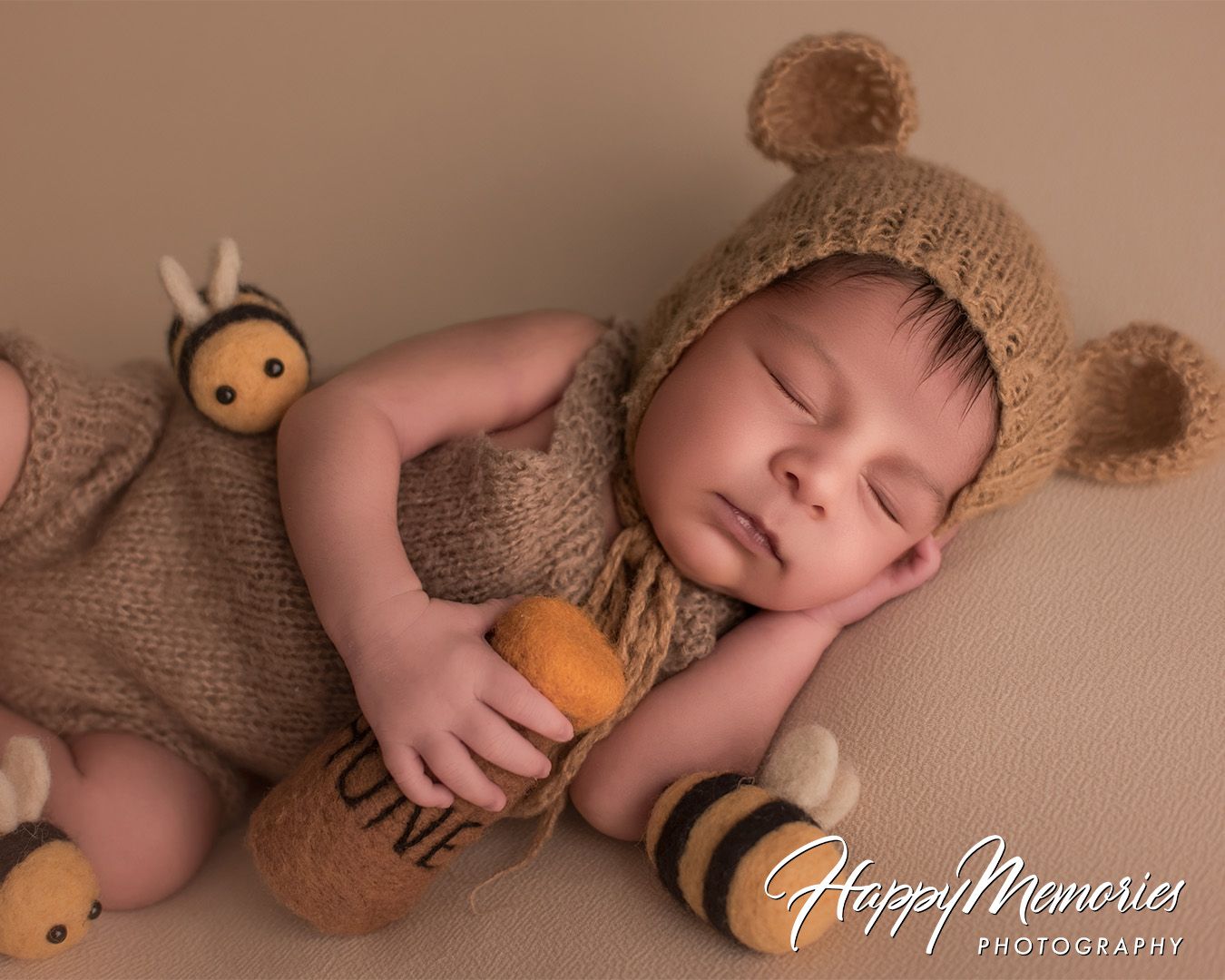 Sweet newborn photo series with baby wearing teddy bear outfit and accessories.
