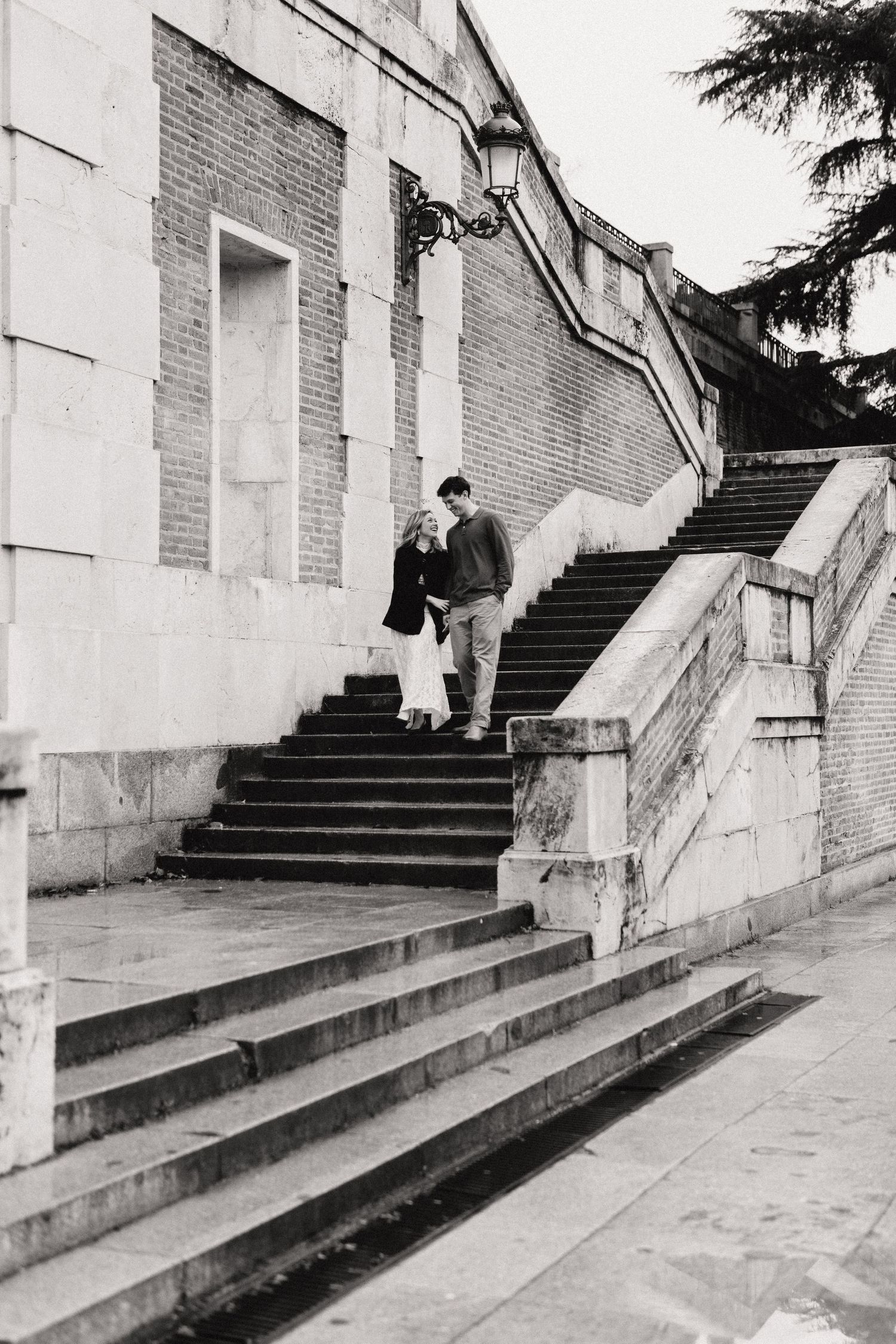 Multiple concrete staircases with white walls and brick accents create a geometric architectural pattern in black and white.