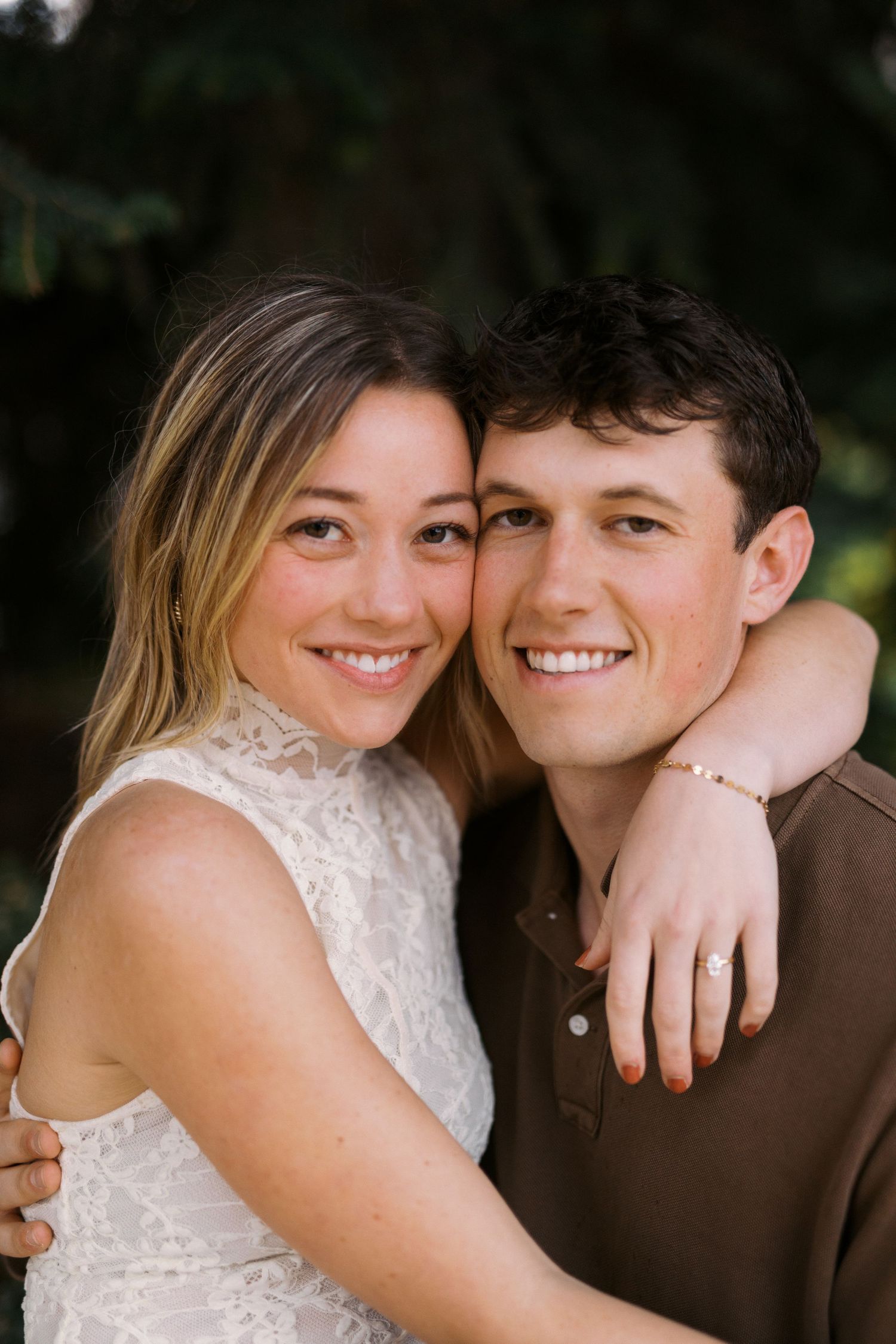 A couple in love poses for a series of romantic engagement photos showing off a ring.
