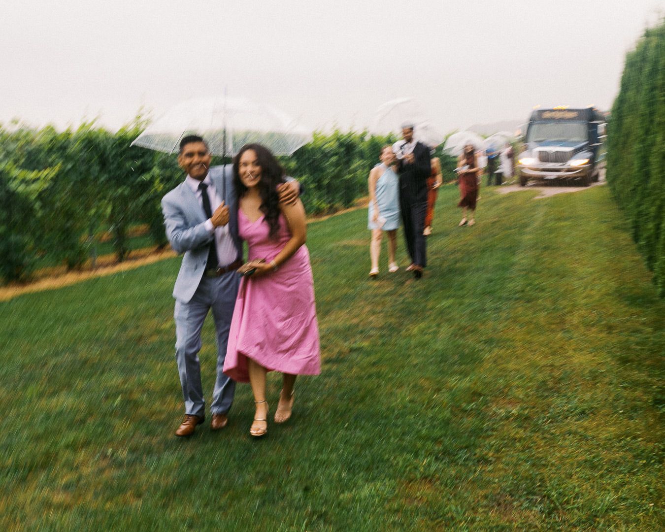 Wedding guests run from rain to enter a wedding reception at Aurora Cellars vineyard in Michigan.