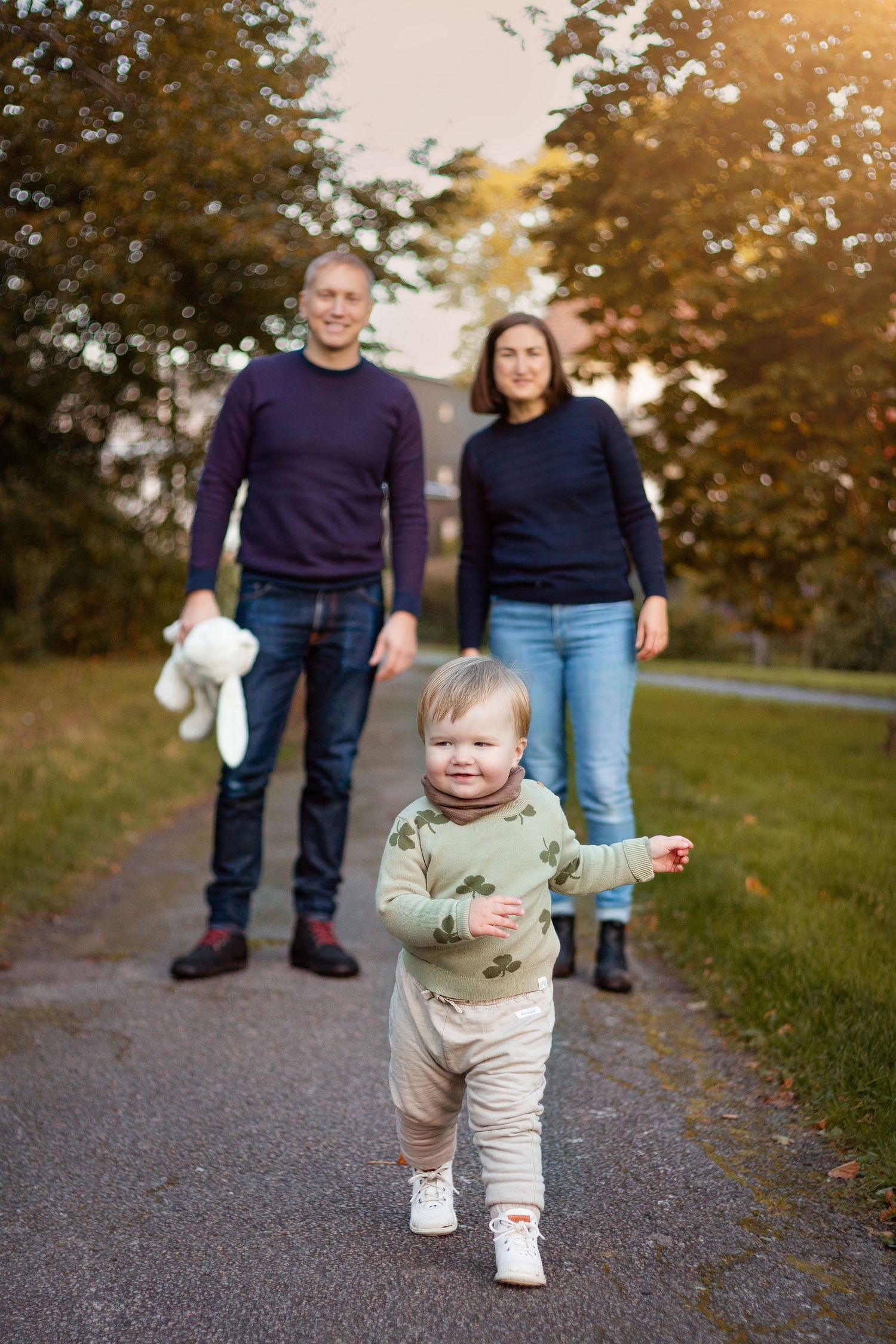 familjefotografering i naturen. mamma, pappa och dotter. Barnet går framför föräldrarna