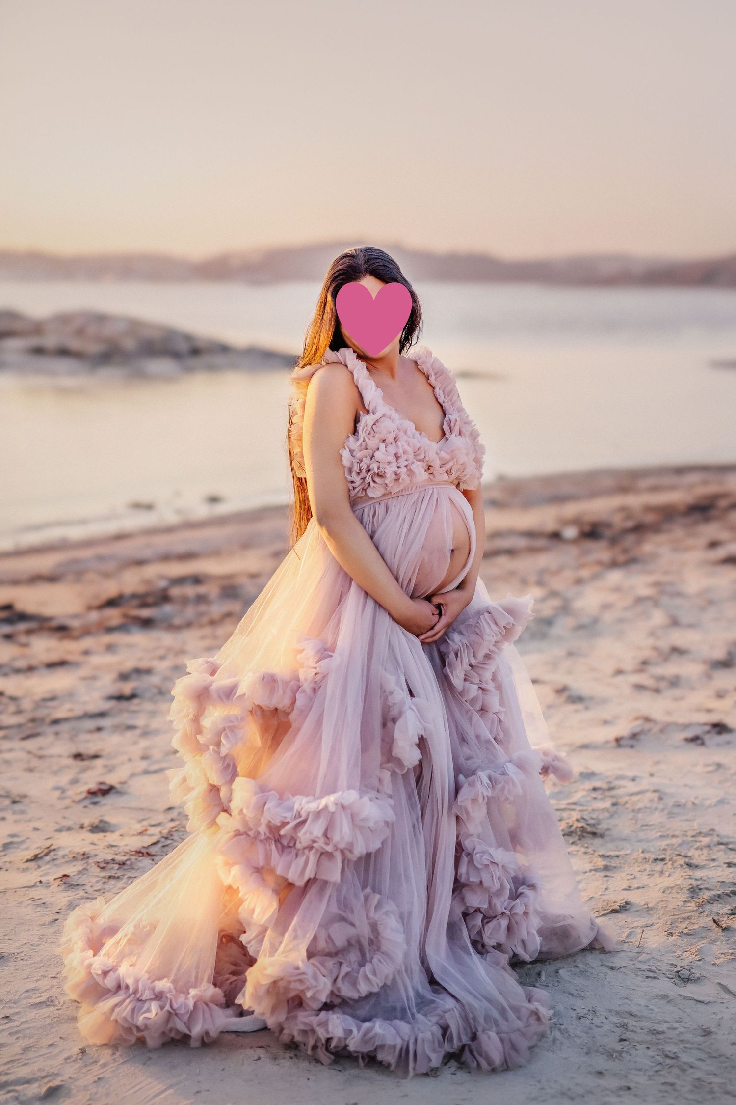 Gravid fotografering på stranden i vacker lyxig klänning.