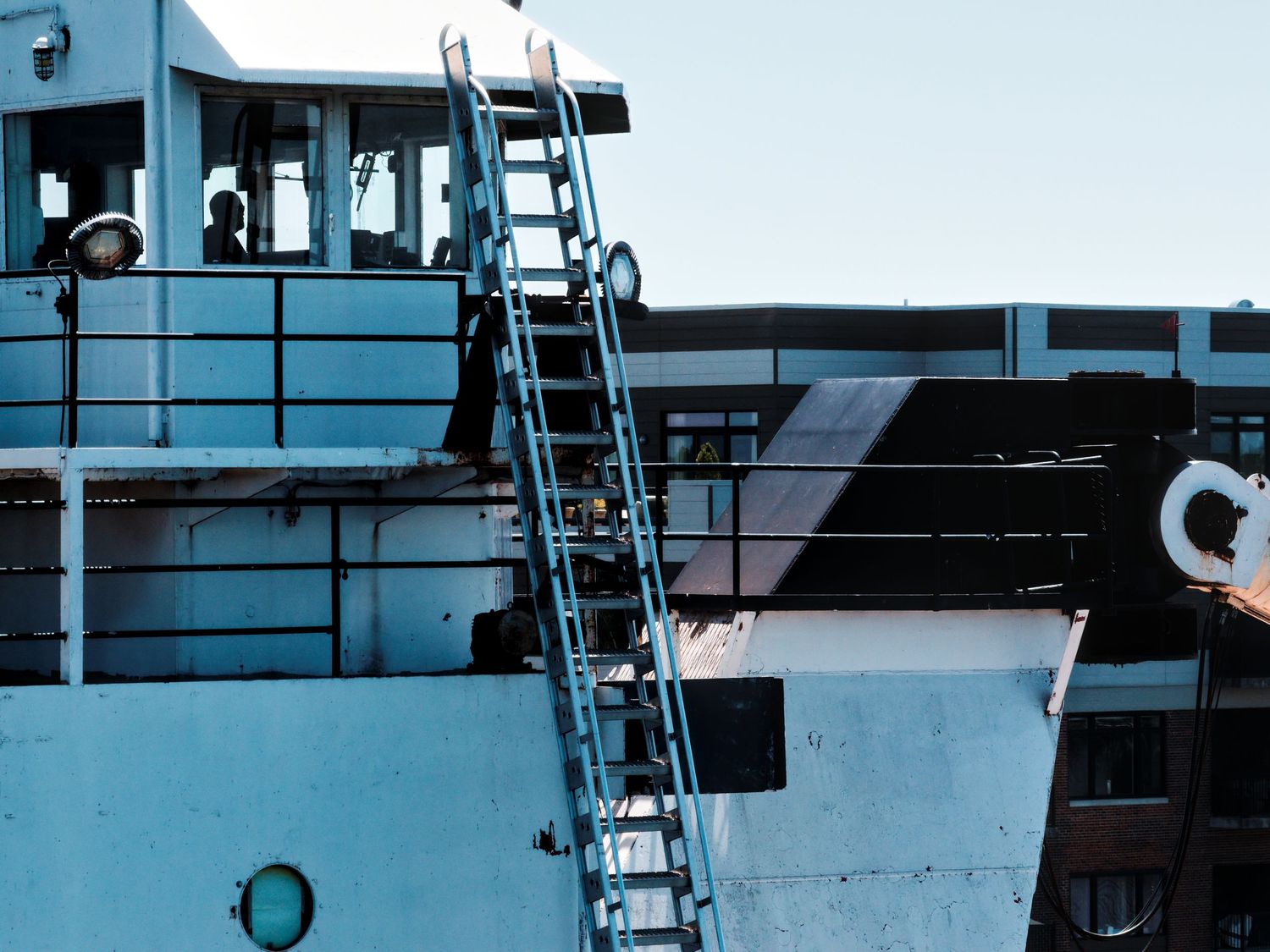 Pilothouse shot of Great Lakes freighter Sam Laud underway in Bay City with silhouette of crew