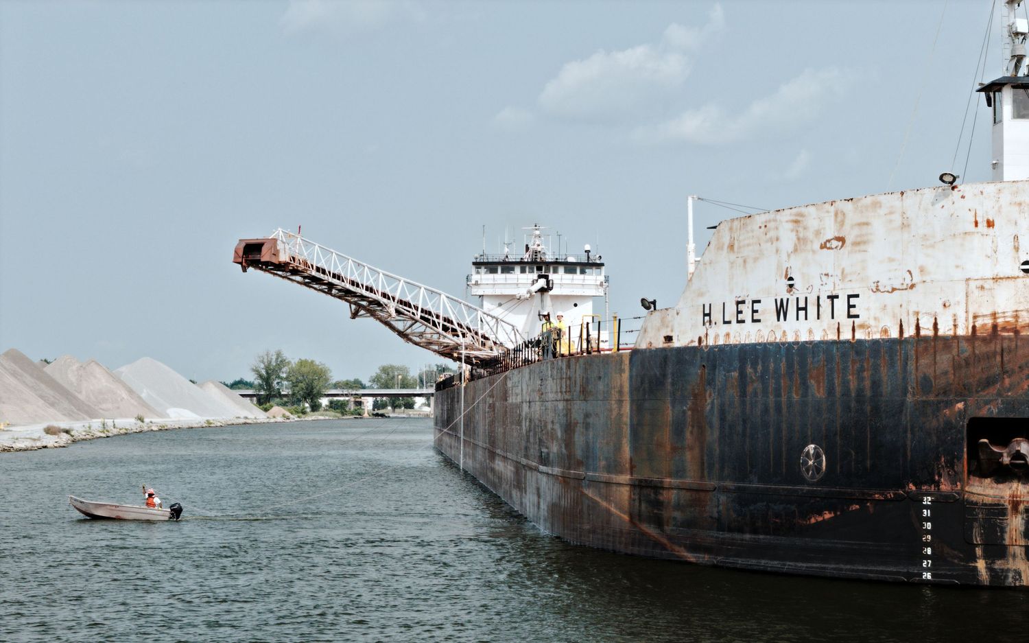Sailor on tender boat Betty White dragging mooring line from Great Lakes freighter H. Lee White to shore in Bay City, Michigan