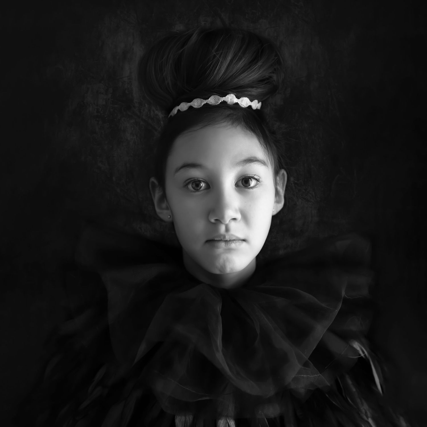Black and white portrait with dramatic lighting and shadows.