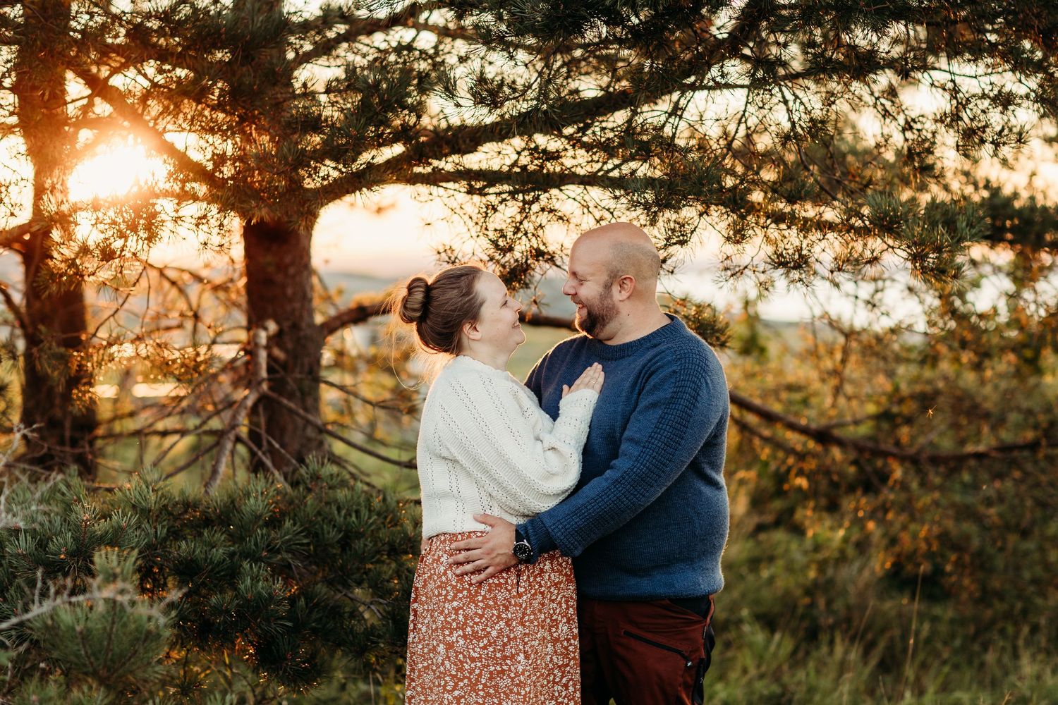 Family portrait session at golden hour in a rustic outdoor setting.
