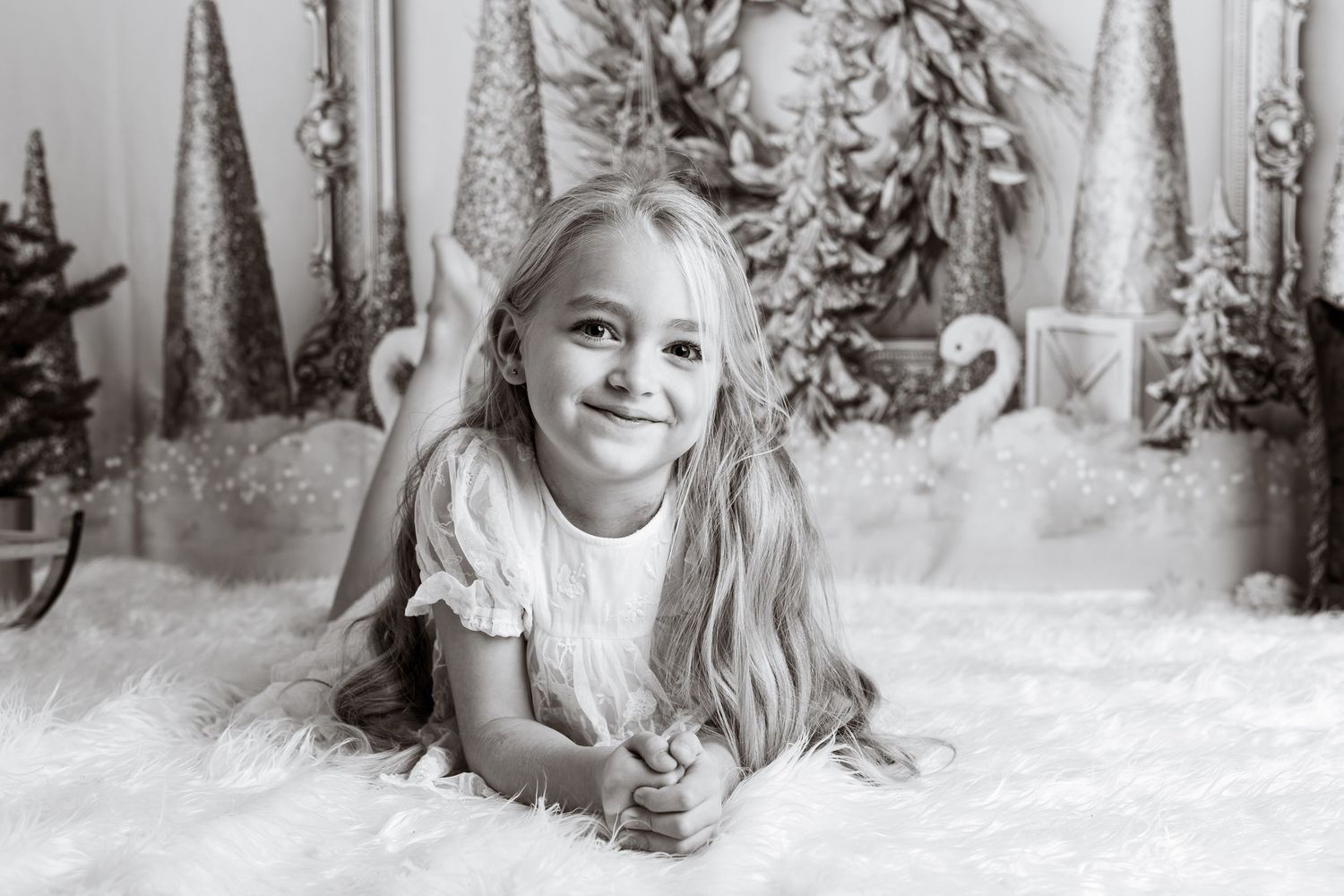 Black and white portrait in winter wonderland themed studio with decorative elements.