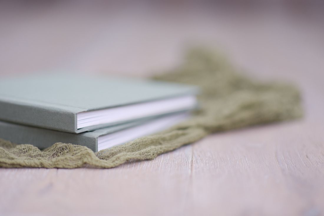 Textured fabric detail of photo album cover in neutral tones.