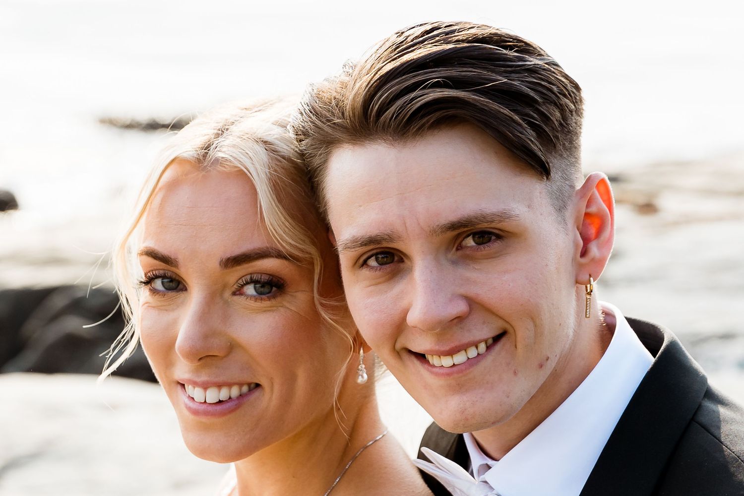 Close up wedding portrait at sunset with coastal background.