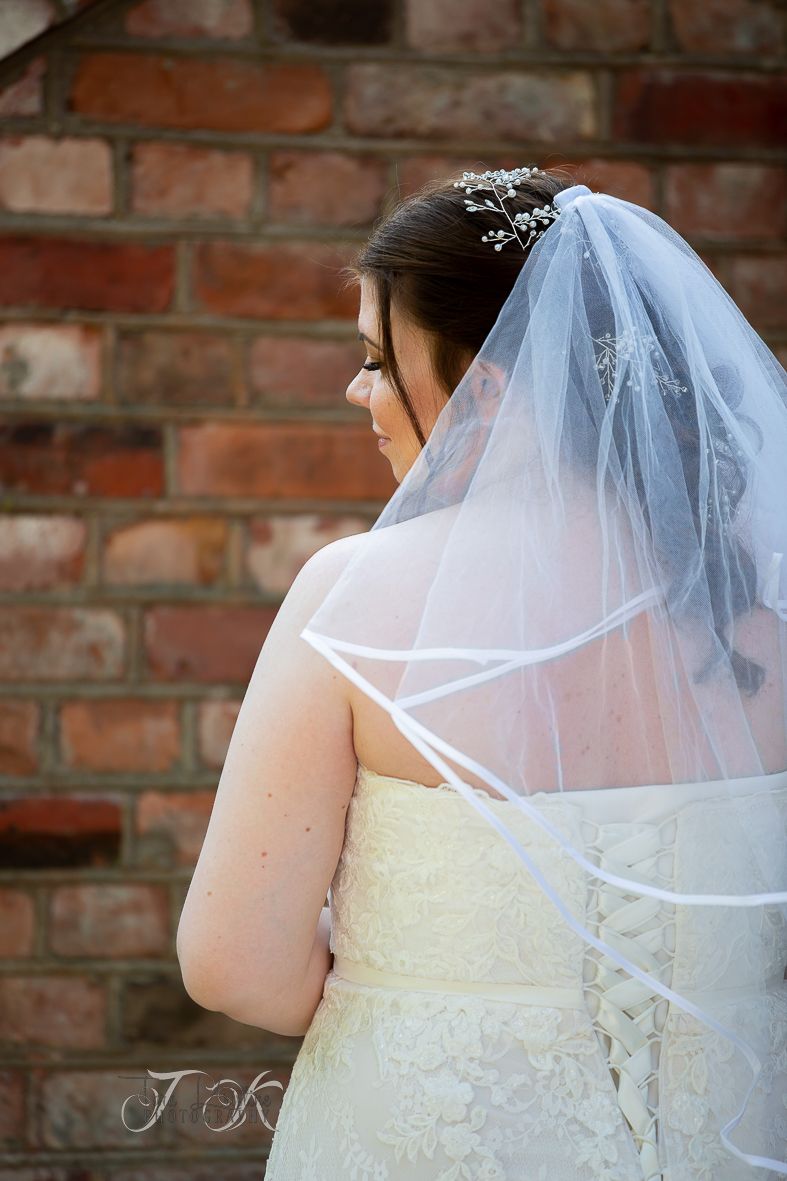 Detail shot of a bride's veil against a brick wall background.