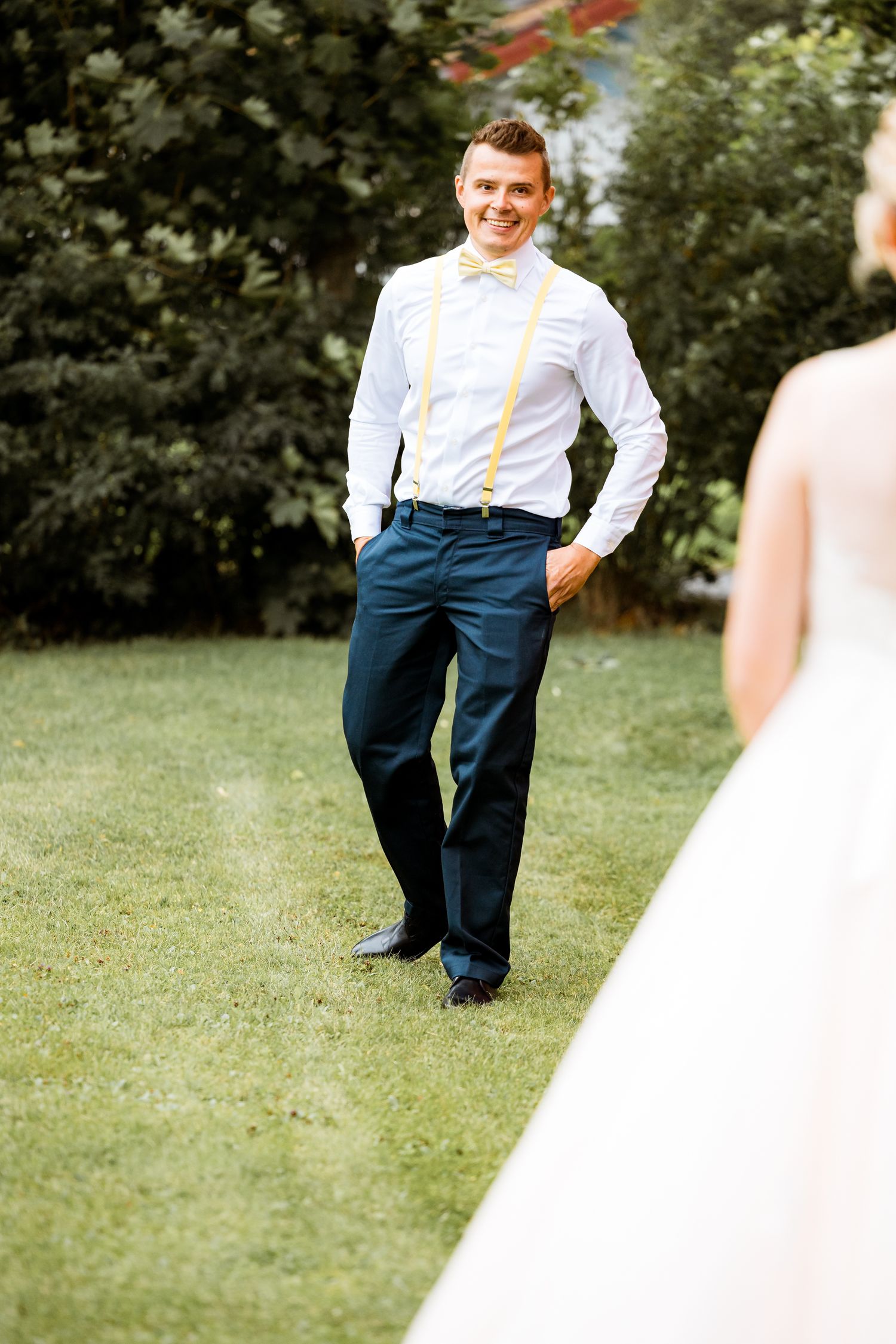 First look sequence in garden with groom in navy pants and yellow bow tie.