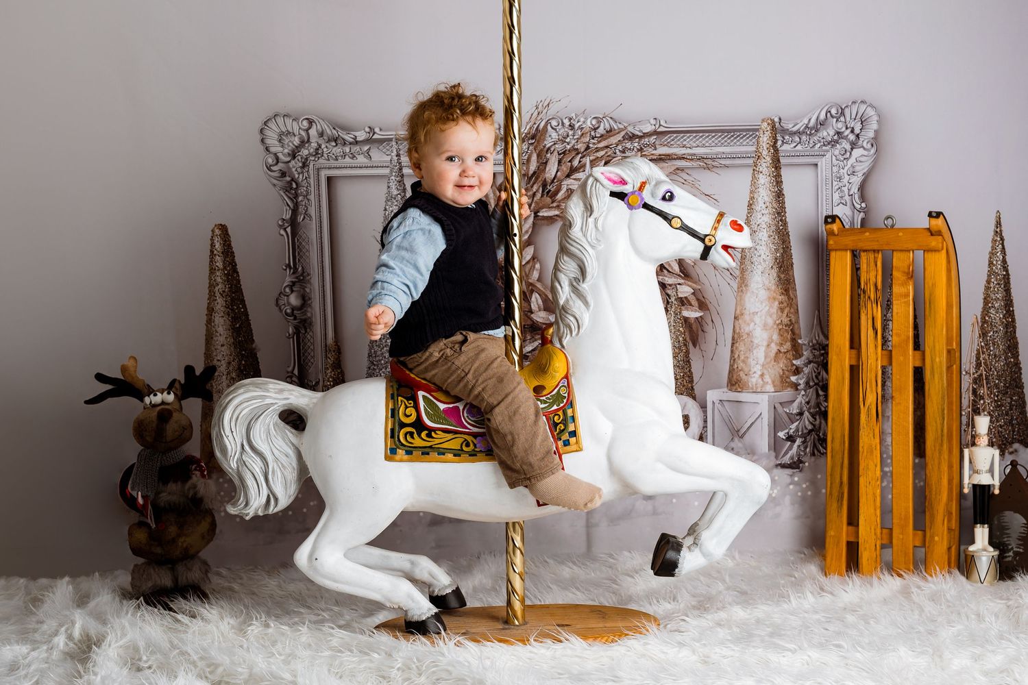 Winter themed photography setup with decorative sleigh and snowy white floor.