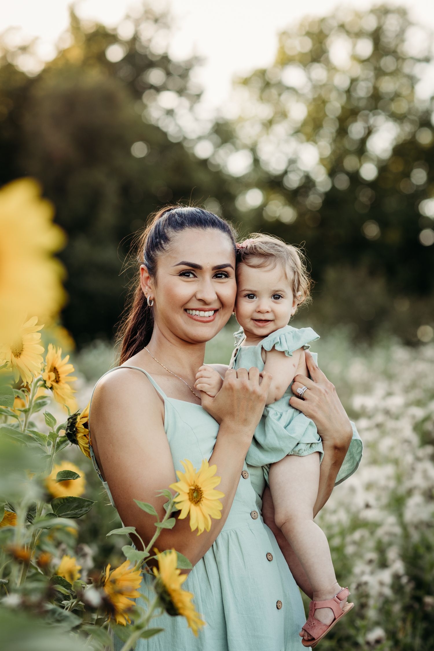 Summer portrait in sunflower field with mint green dress and joyful expressions.