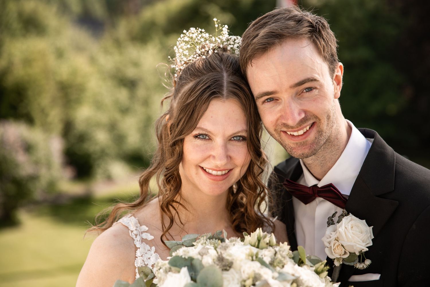 Wedding couple shares joyful moments in an outdoor garden setting.