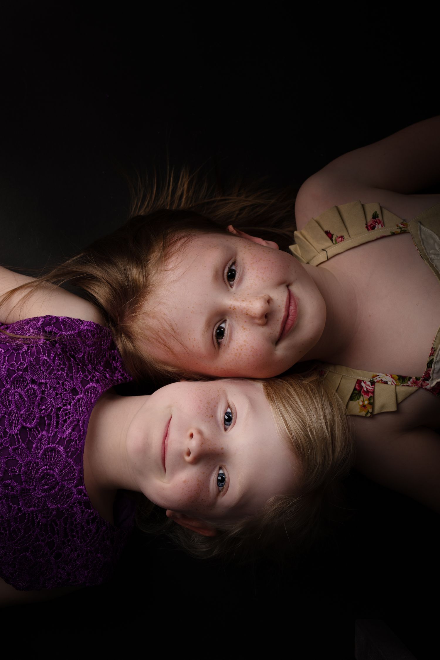 Intimate low-key portrait in purple and floral dresses.
