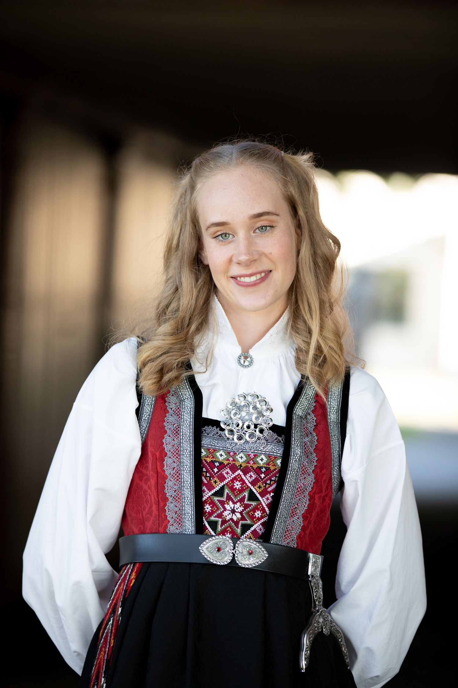 Traditional Norwegian folk costume featuring black and red vest with silver brooch details.