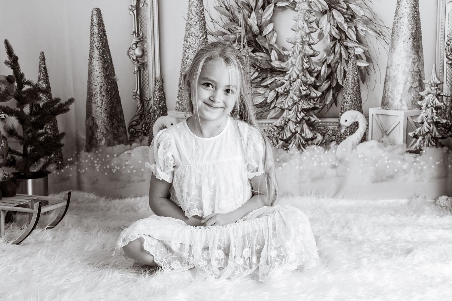 Black and white studio portrait with winter themed backdrop and decorative elements.