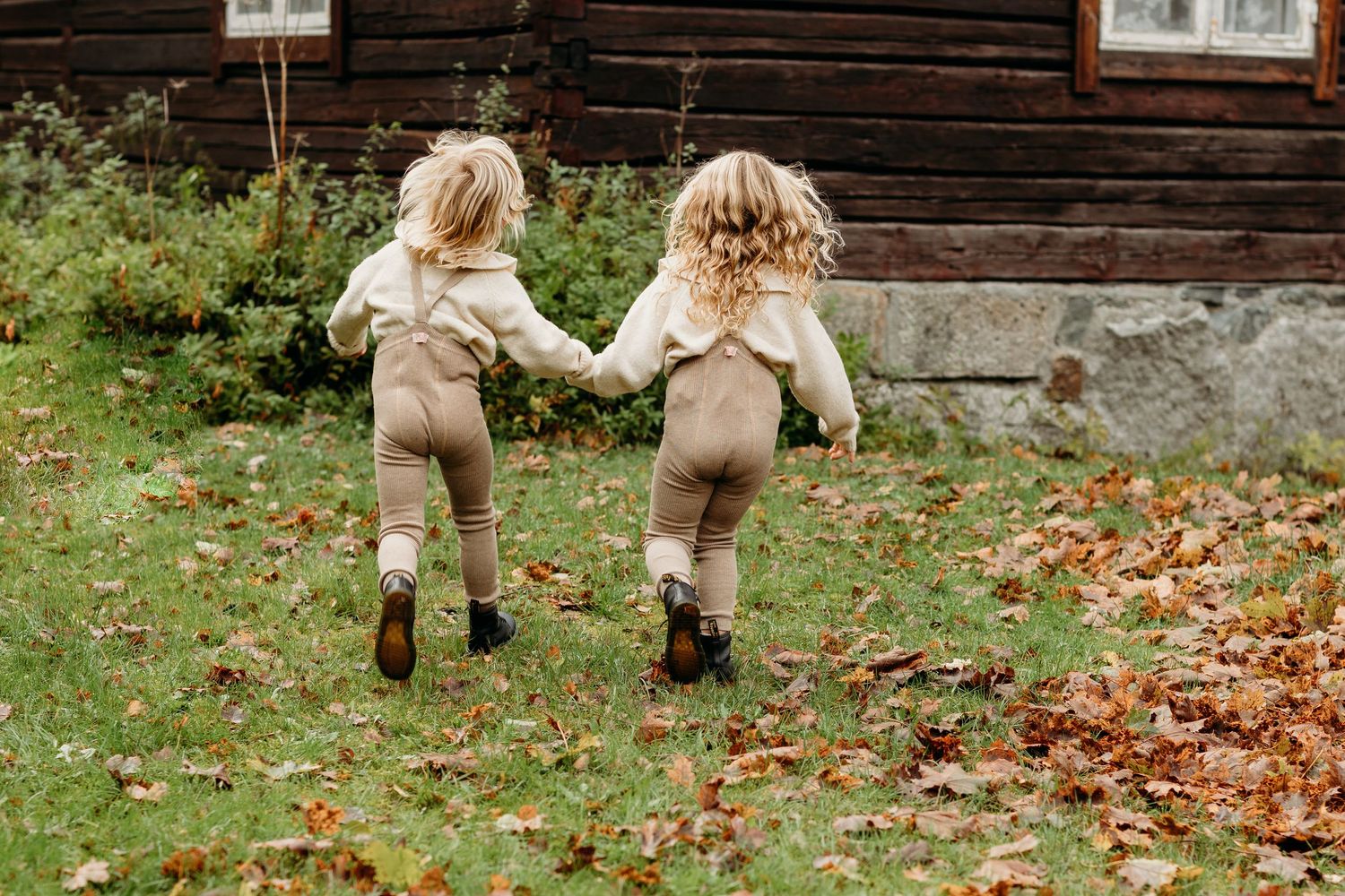 Legs and boots visible on ground with scattered autumn leaves.
