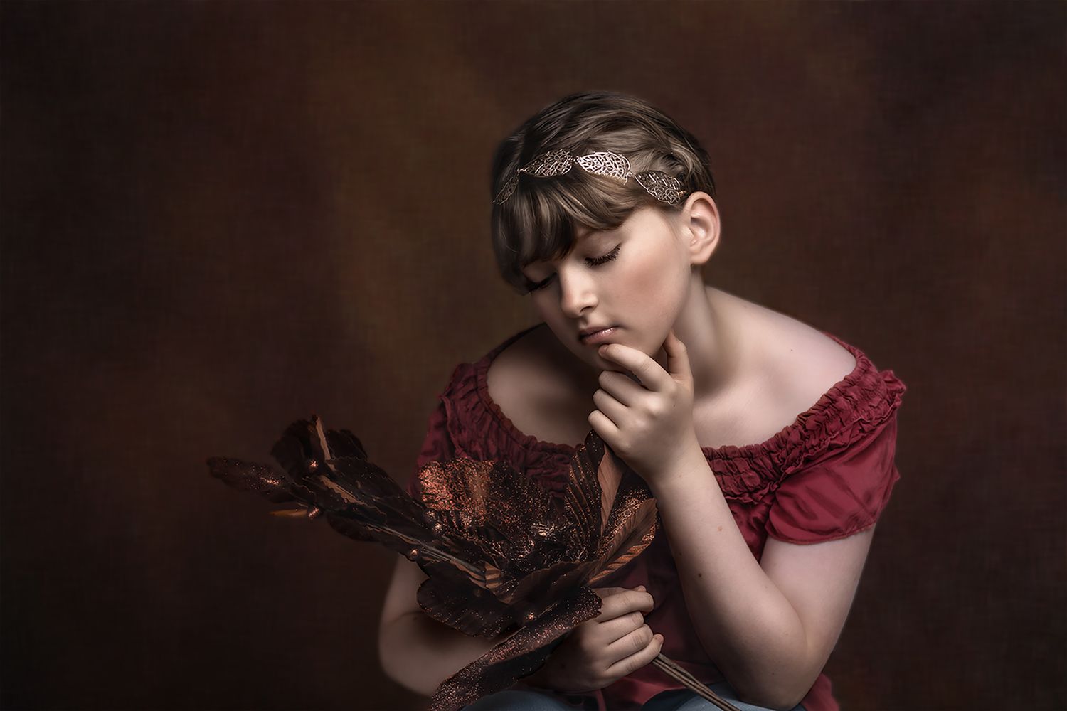 Artistic portrait in burgundy tones featuring dramatic lighting and shadows.
