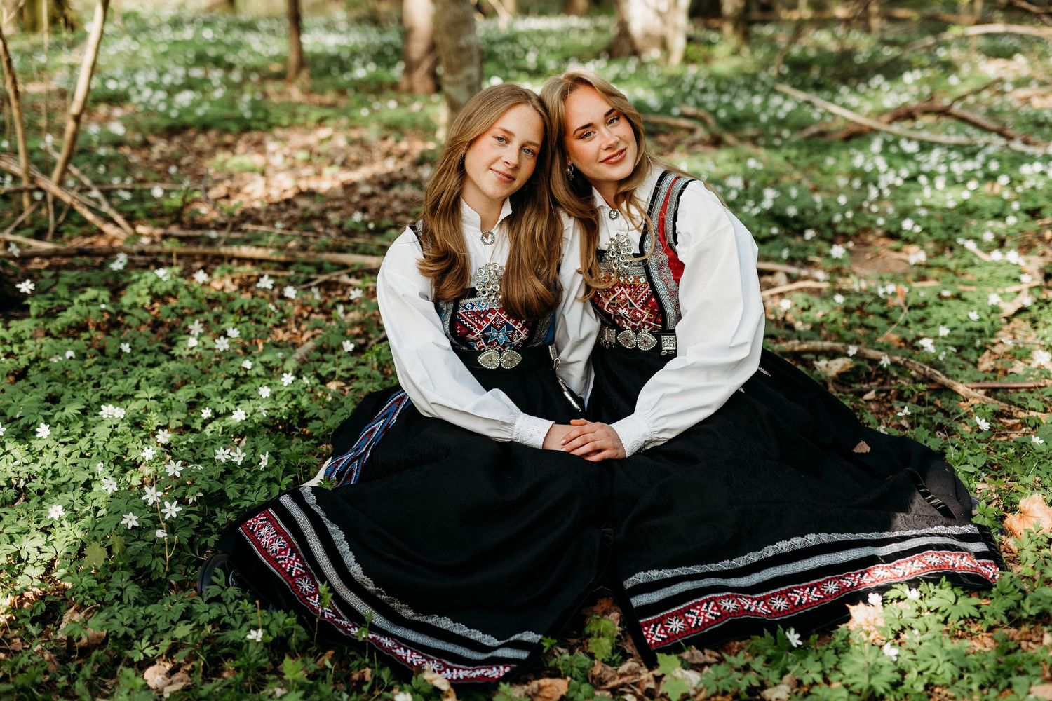 Traditional folk dresses photographed in natural woodland setting.