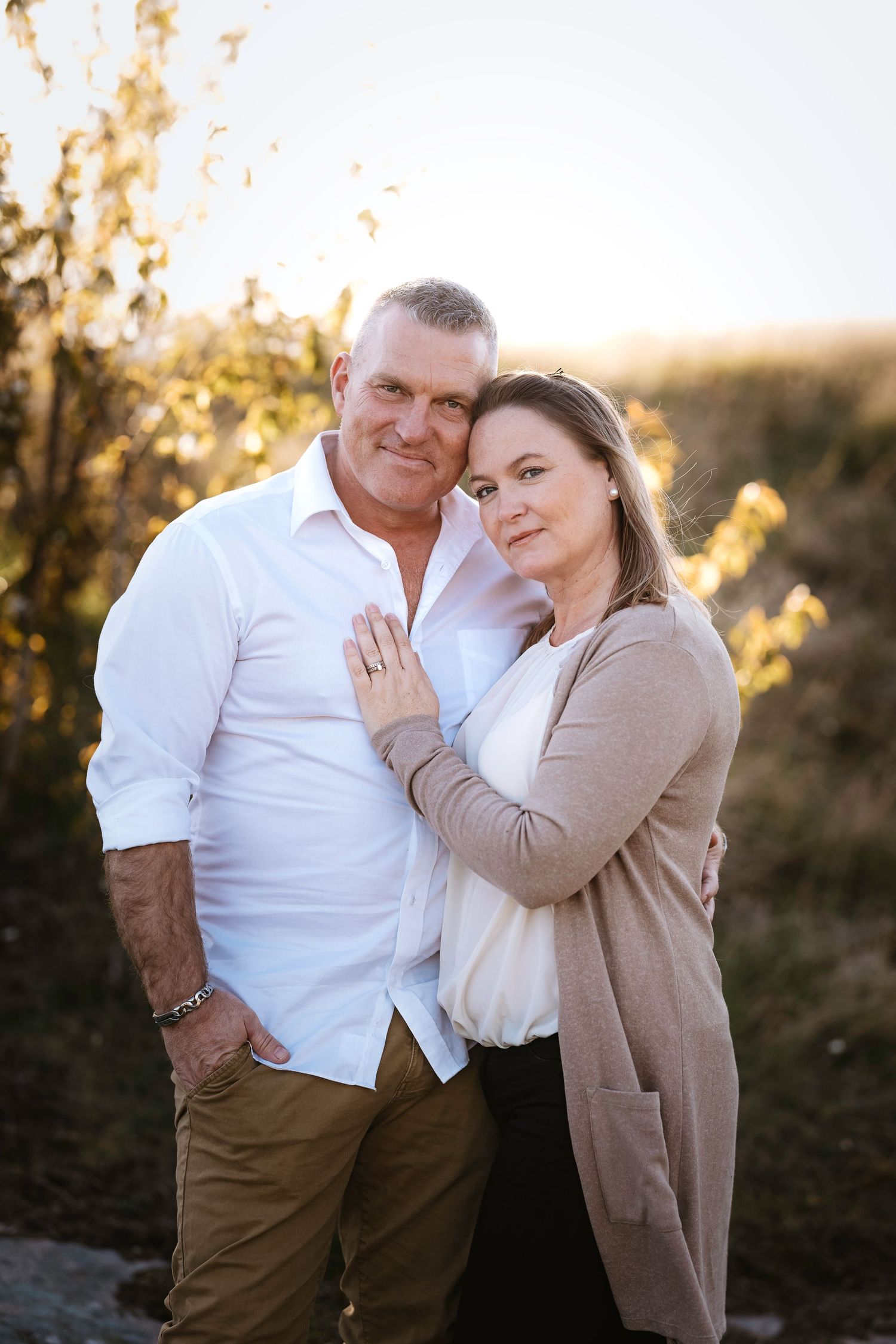 A couple in casual attire sharing an intimate moment at sunset.