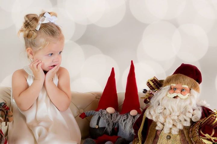Whimsical holiday decorations including red gnomes and white ornaments against a light background.