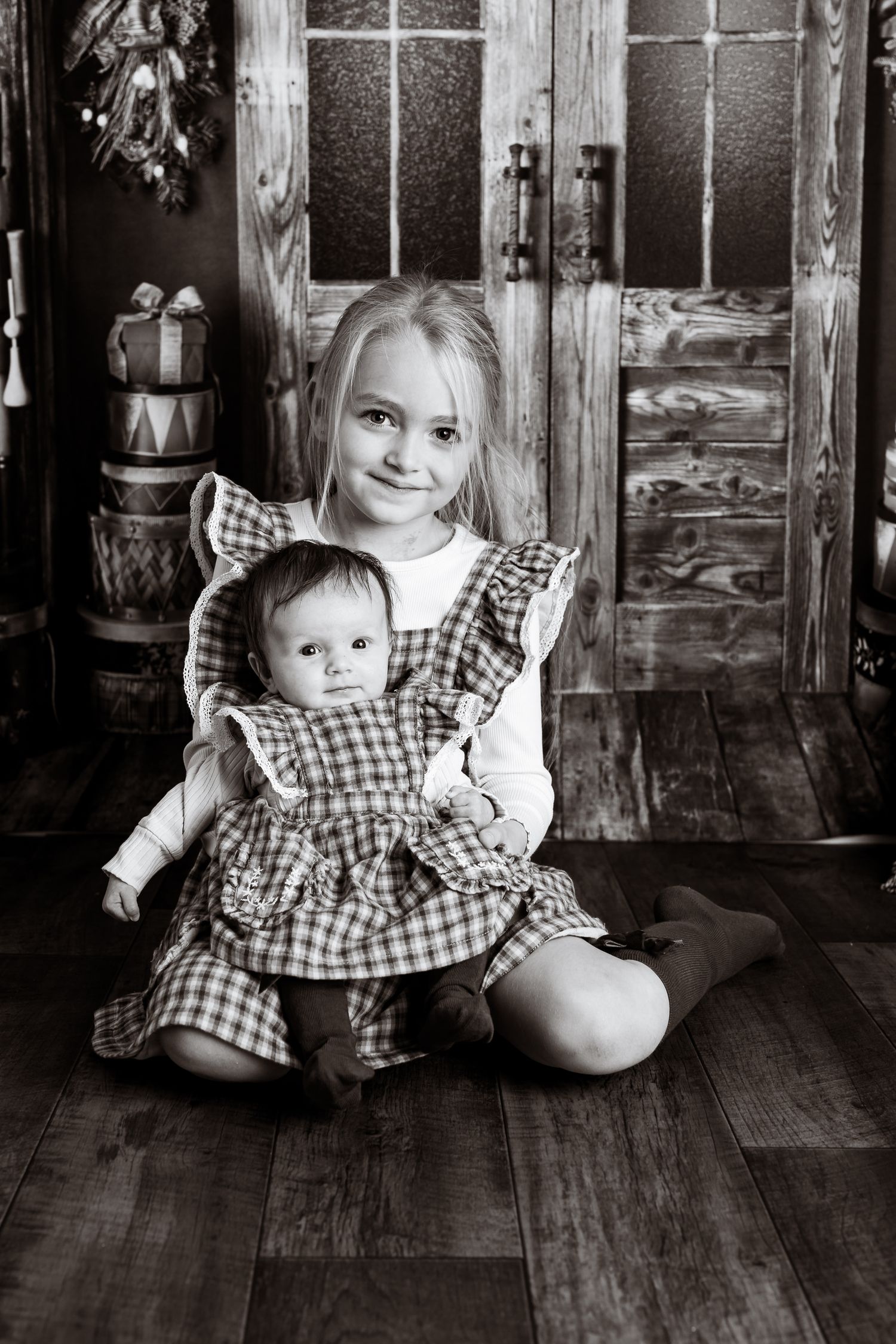Black and white portraits showing matching gingham dresses in a vintage holiday setting.