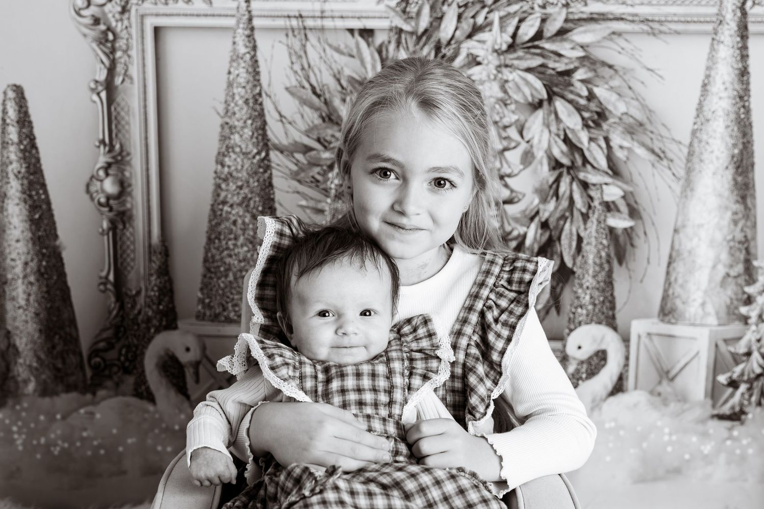 Artistic black and white studio portrait with winter wonderland decorations and props.