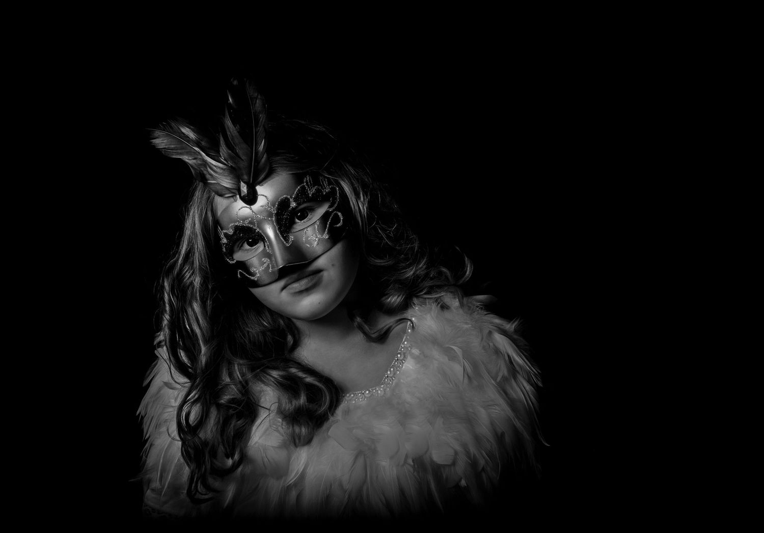 Artistic dark portrait with feathers and decorative mask.