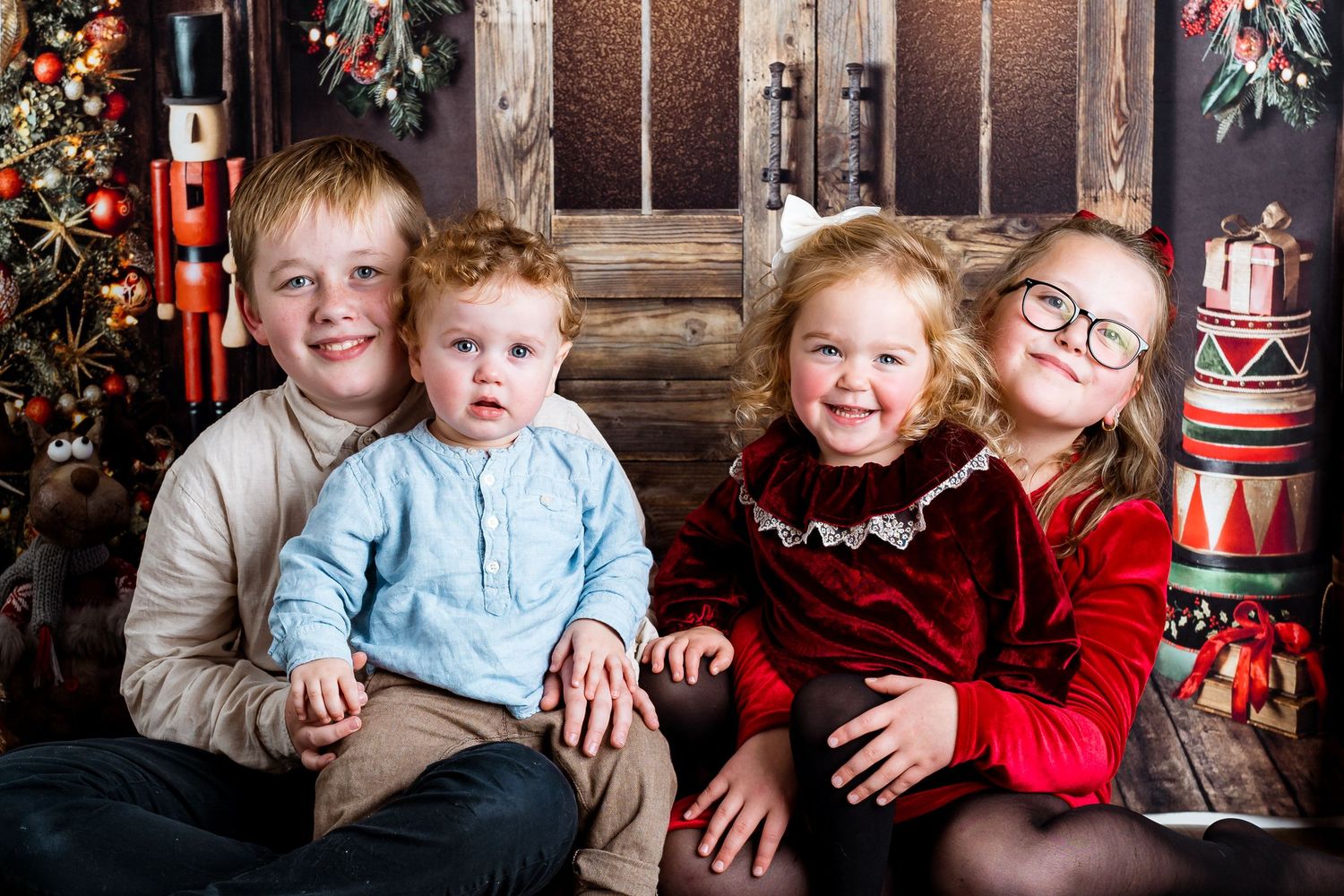 Festive family photo session with nutcracker decorations and holiday greenery.