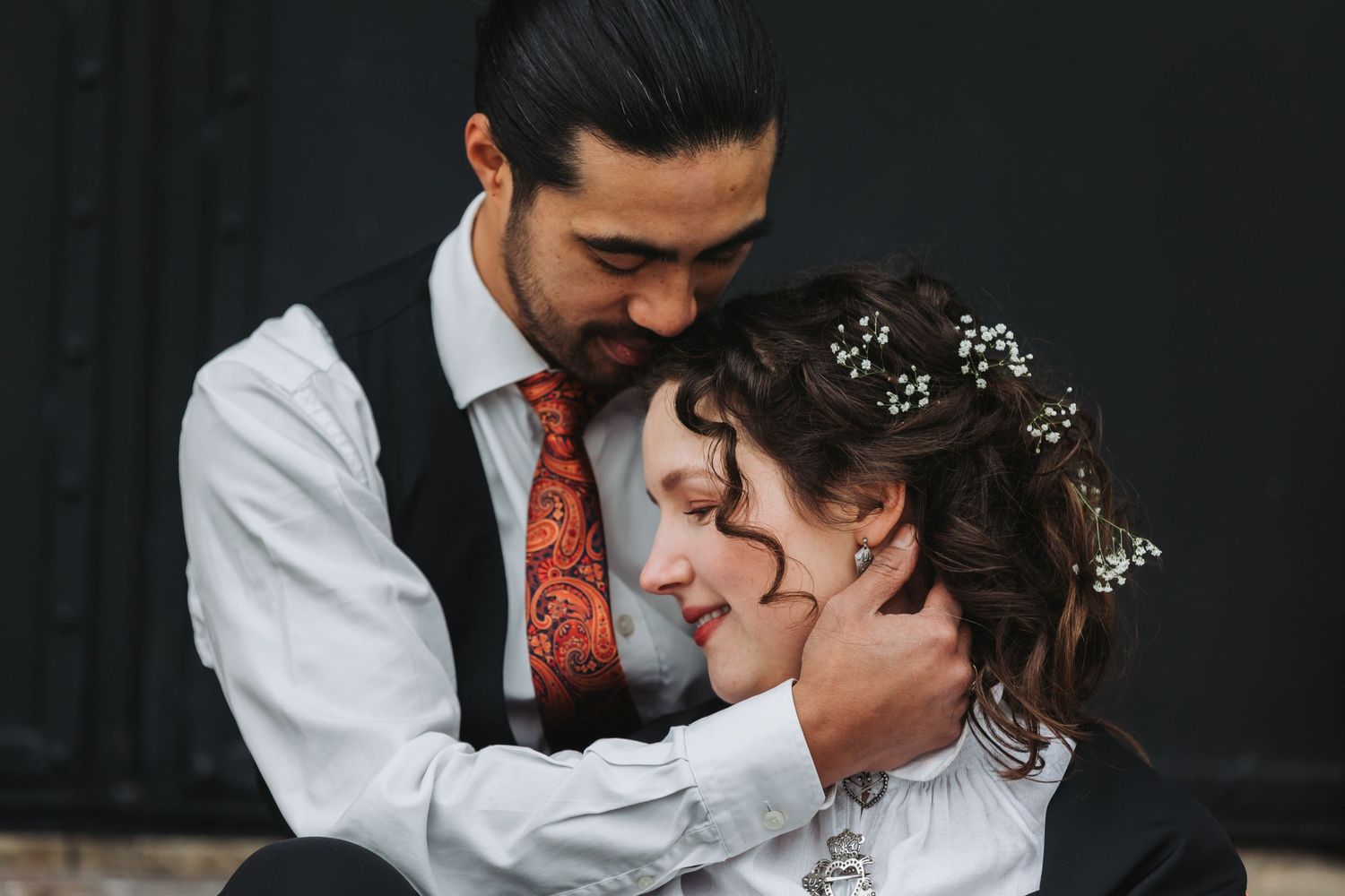 A romantic moment captured in a dark studio setting.