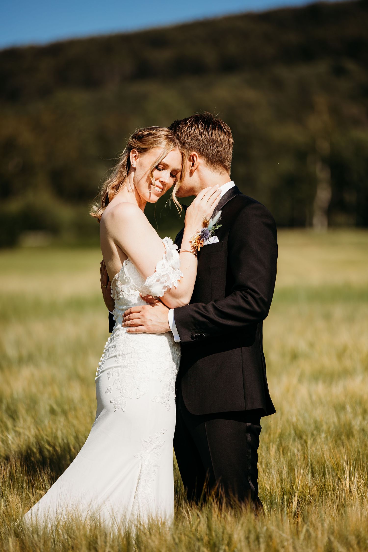 Romantic wedding portraits in golden wheat field at sunset.