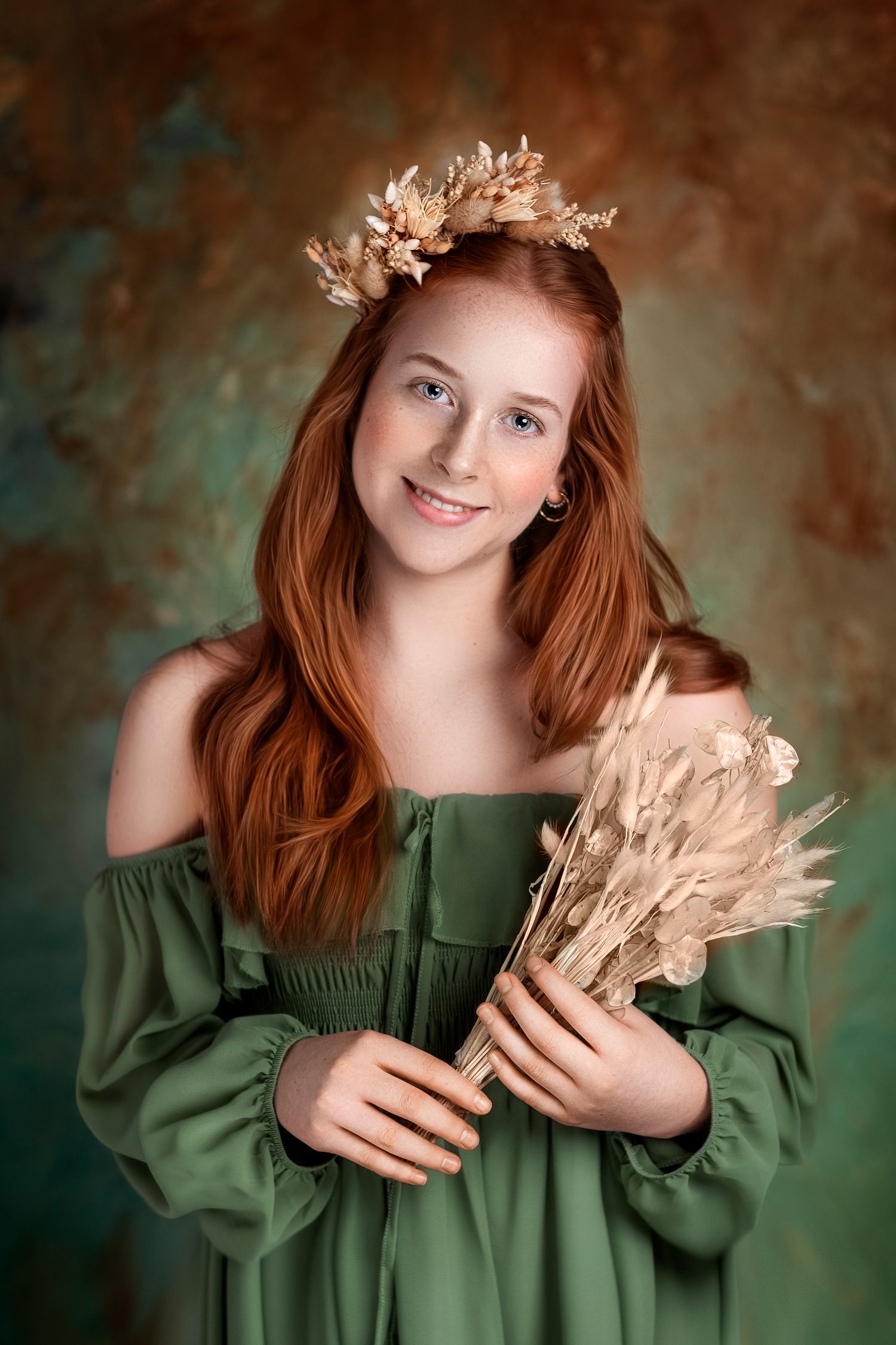 Portrait with dried floral crown and wheat bouquet in off-shoulder green dress against textured background.