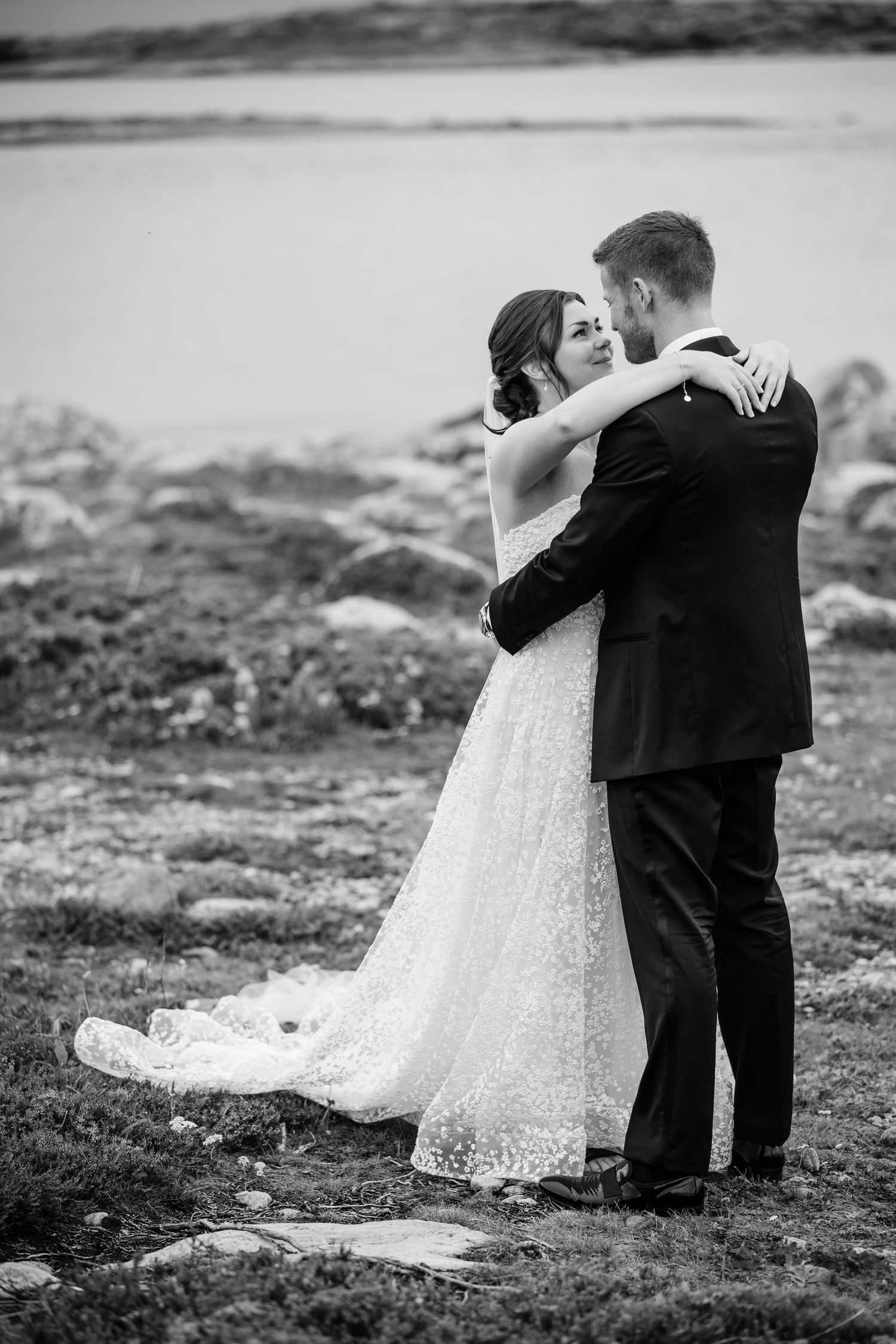Black and white wedding portraits captured on rocky coastal terrain.