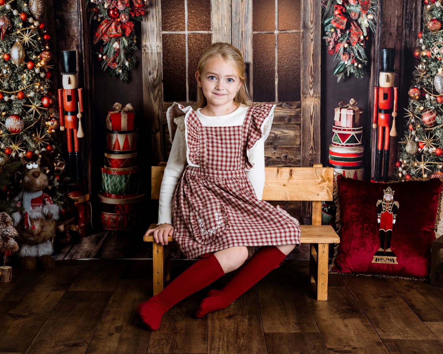 Christmas photo series with vintage wooden bench and festive nutcracker decorations.