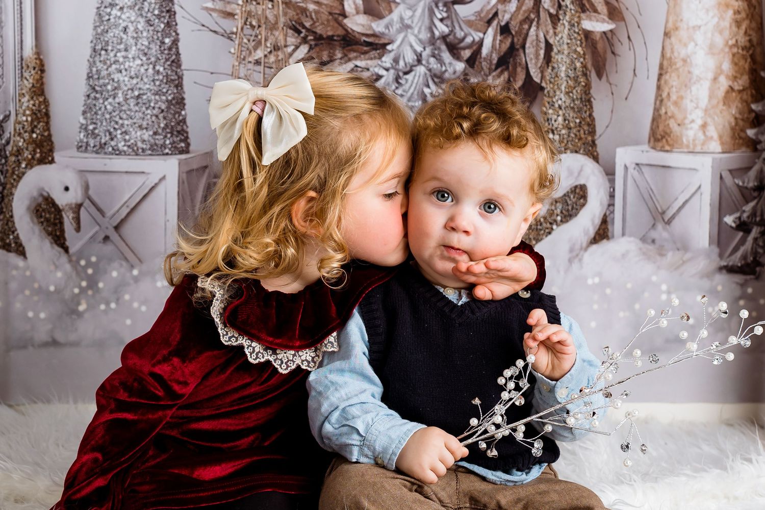 Festive winter photo session with sparkly silver decor and snowy white setting.
