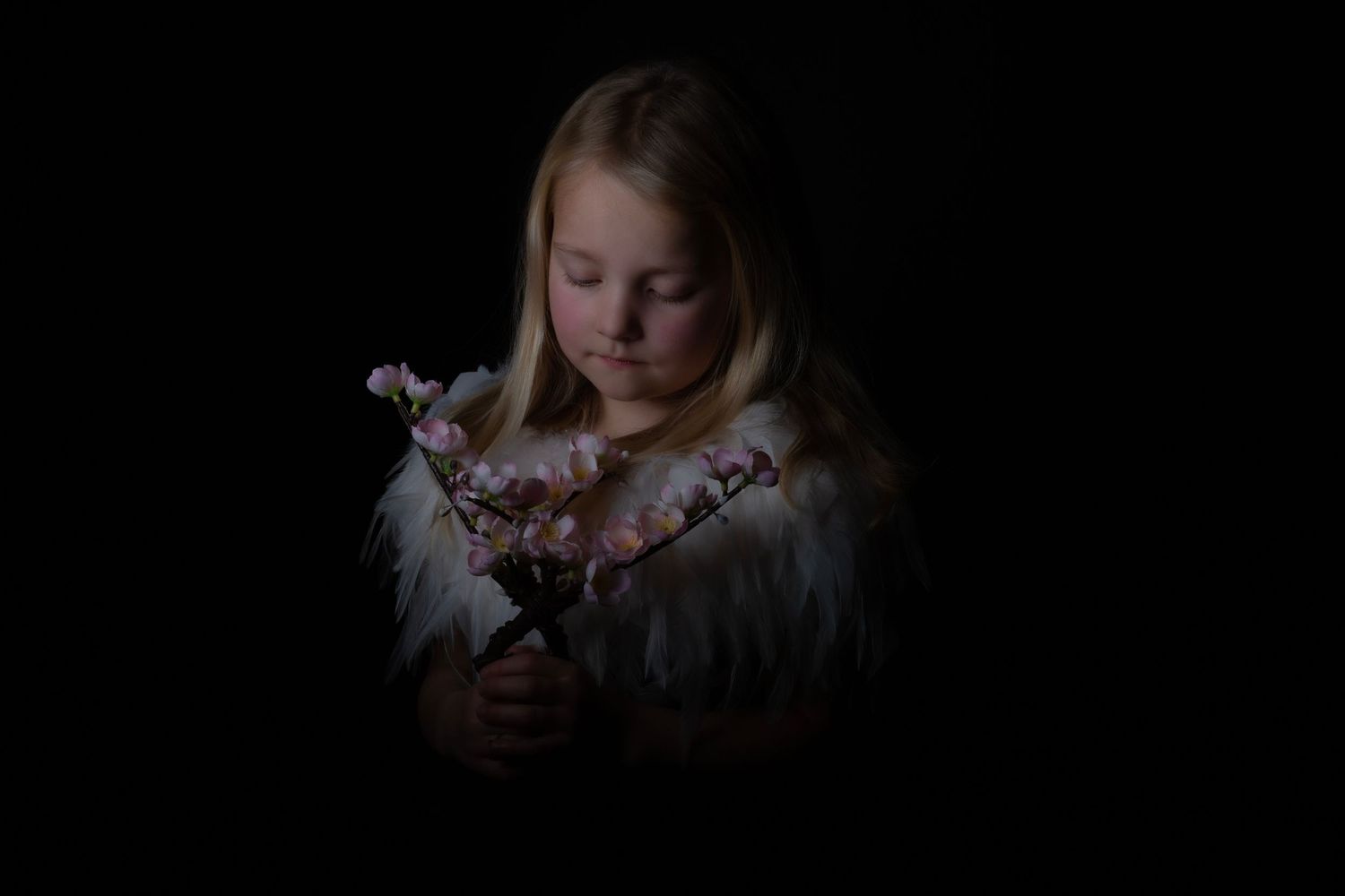 Moody artistic portrait with cherry blossoms in dark setting.